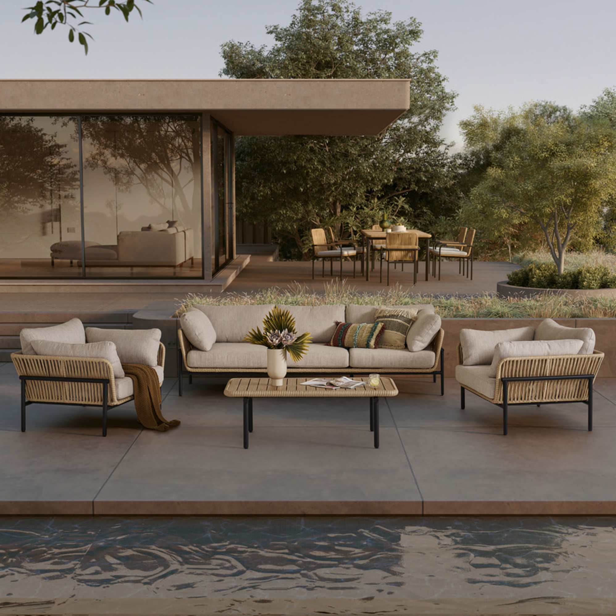 A outdoor wicker sofa, lounge chair, and coffee table set placed on the front porch.