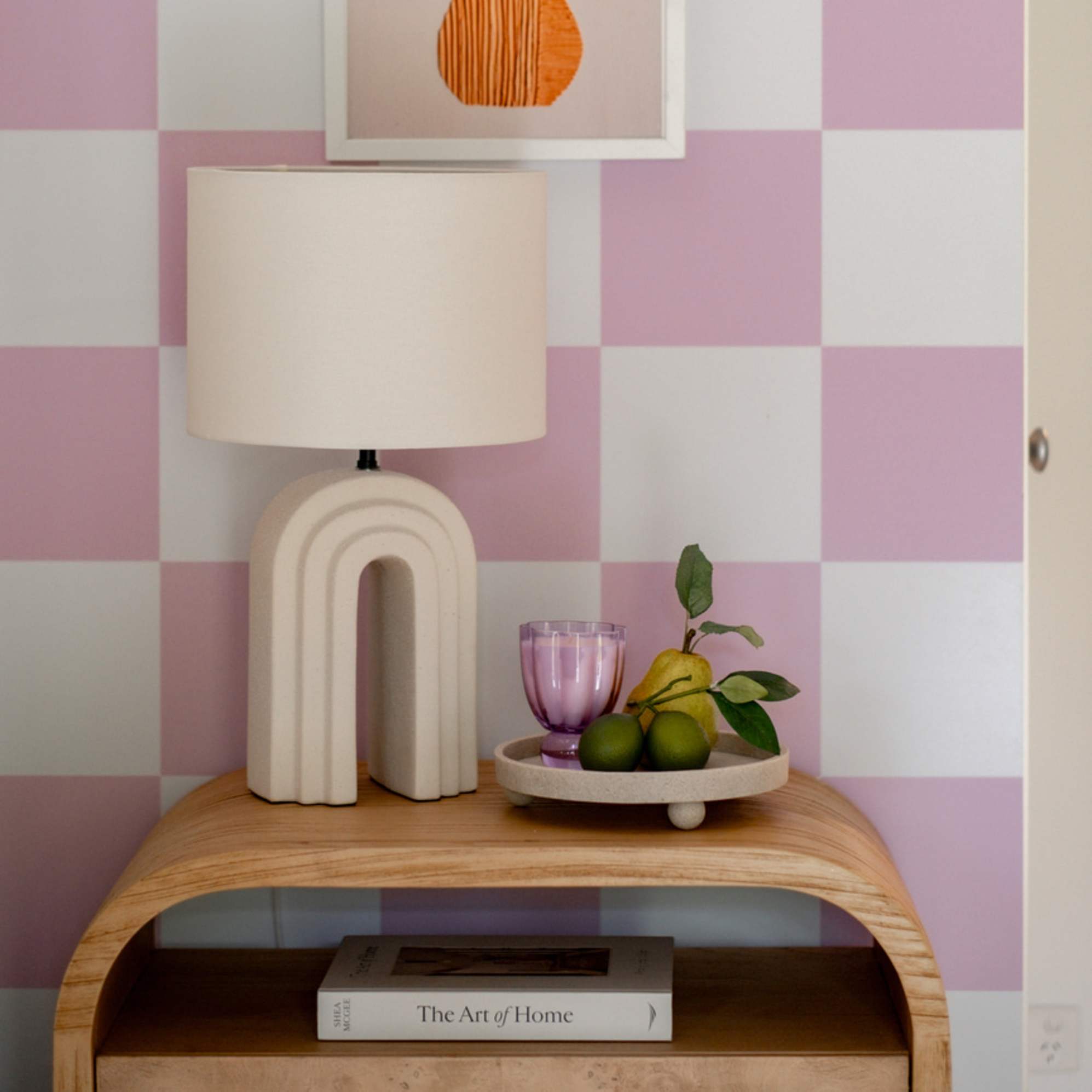 An arched table lamp placed on a bedside table.