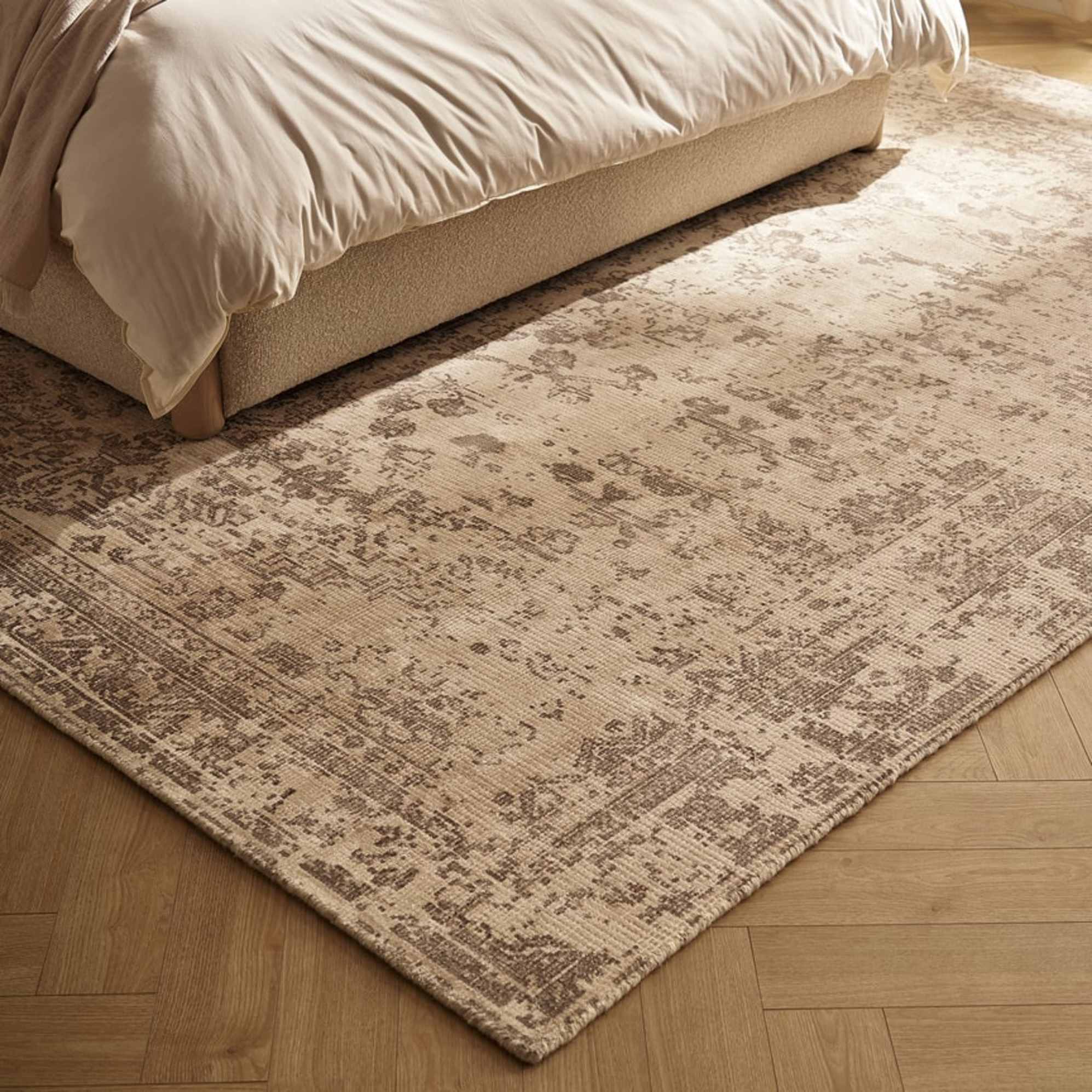 An area rug placed beneath a bed in the bedroom.