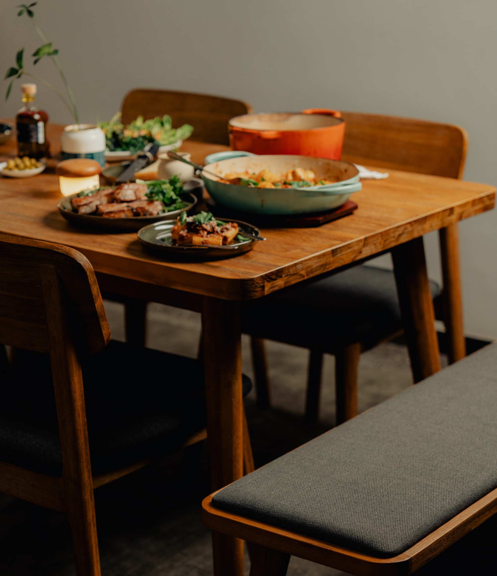 An acacia wood extendable dining table with plates of food.