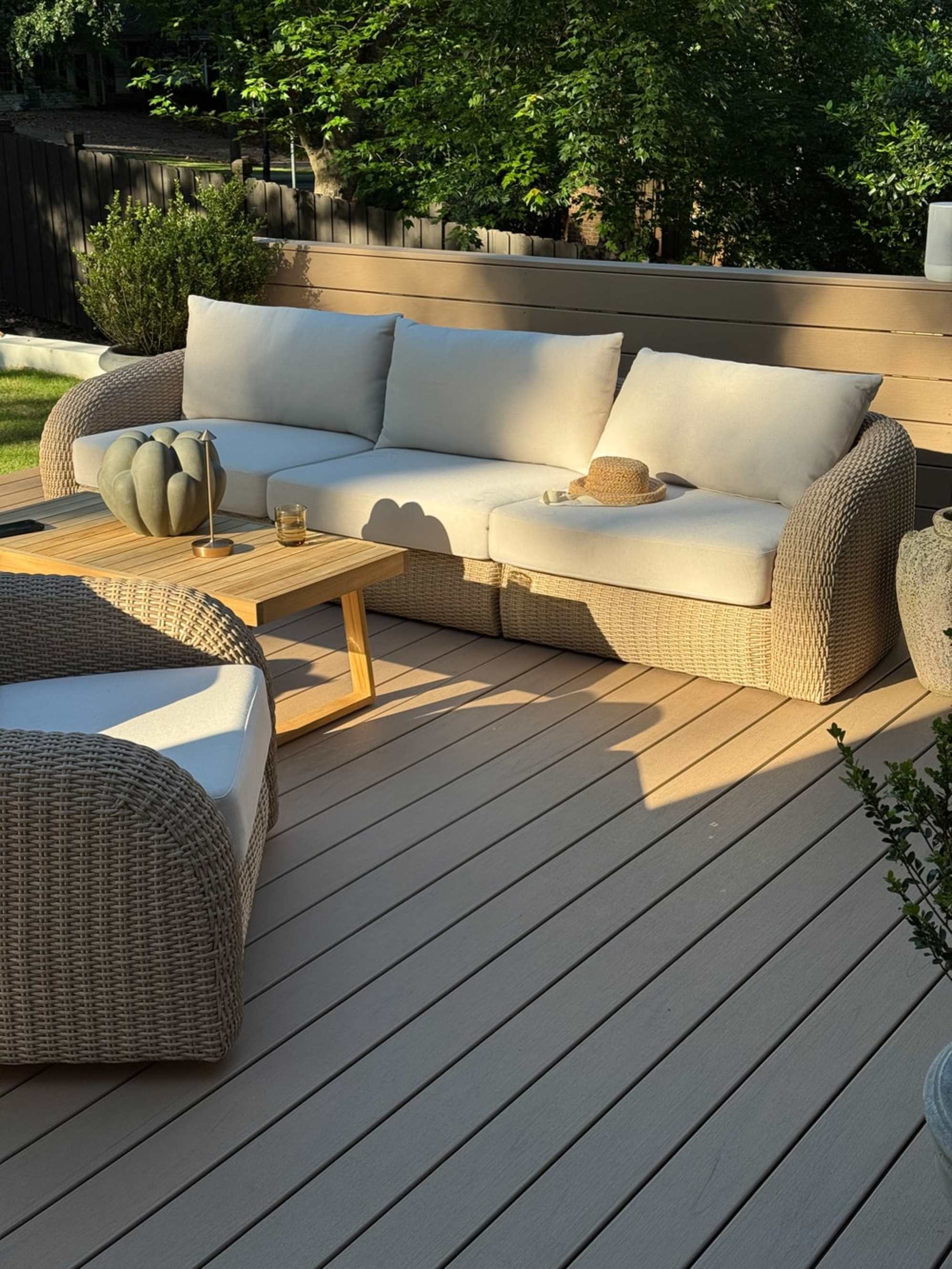 A wicker outdoor sofa placed on a deck.