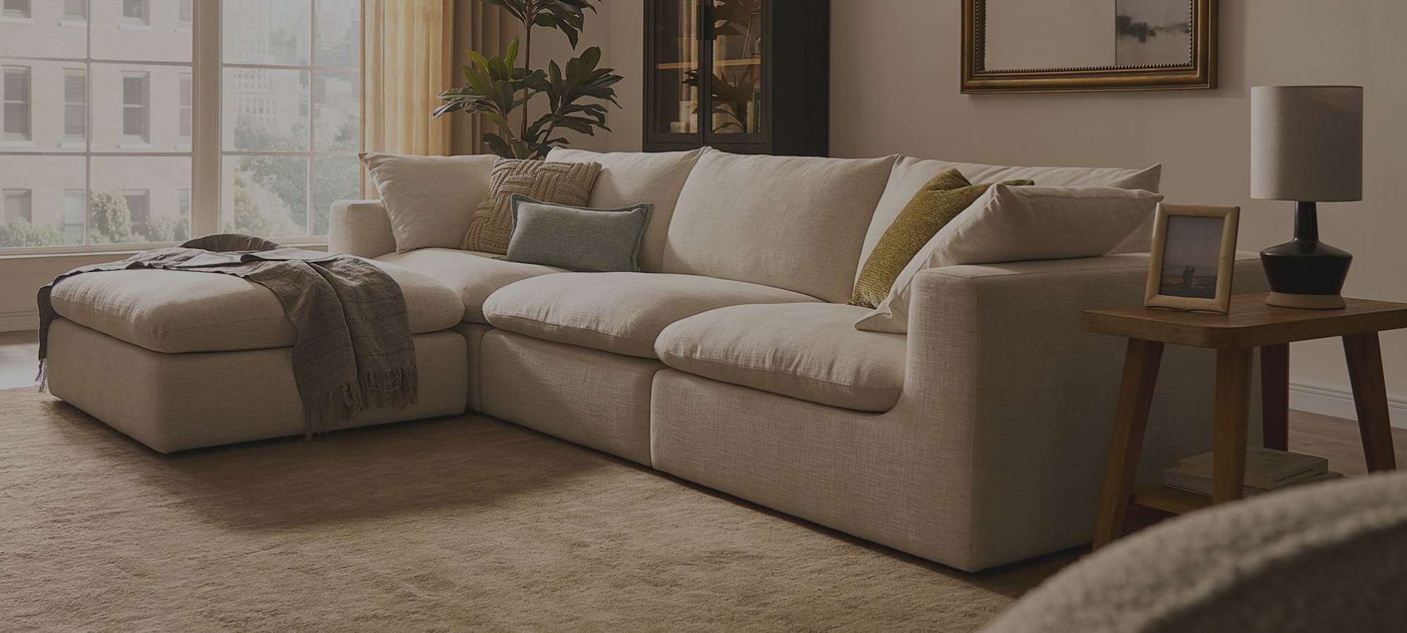 A white extended sofa with a matching ottoman.