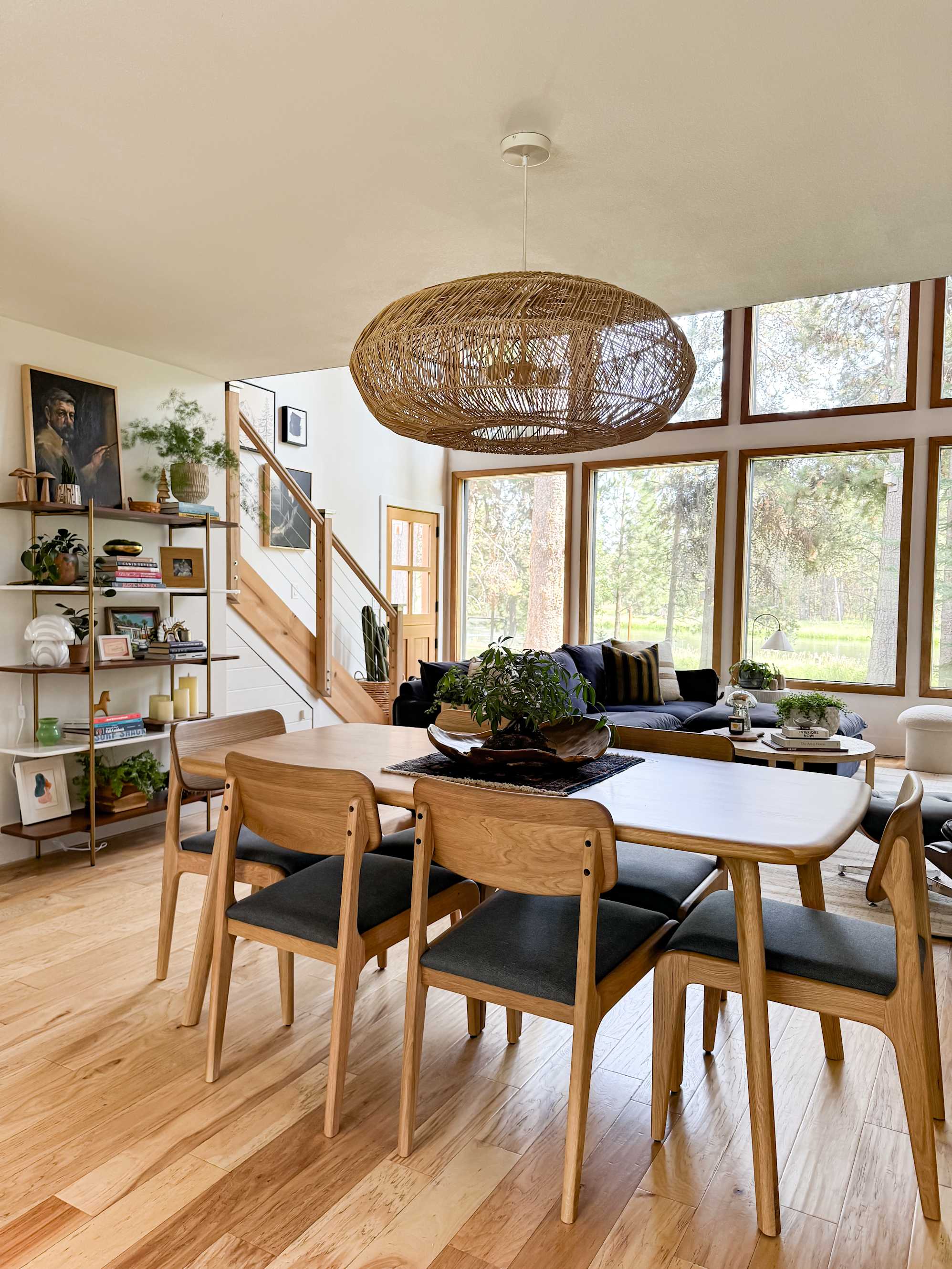 A shelf, dining table, sofa and coffee table in an open living room space.