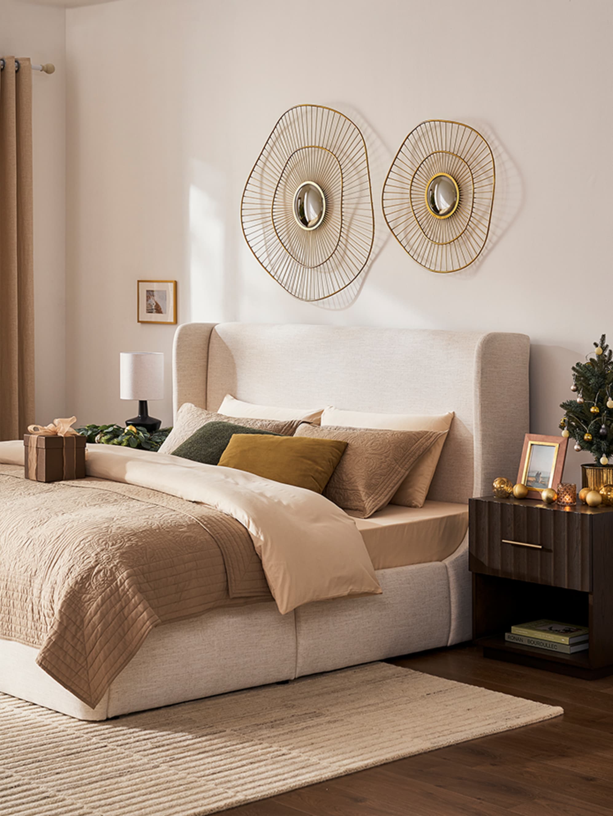 A bed with a fabric headboard placed in a bedroom.