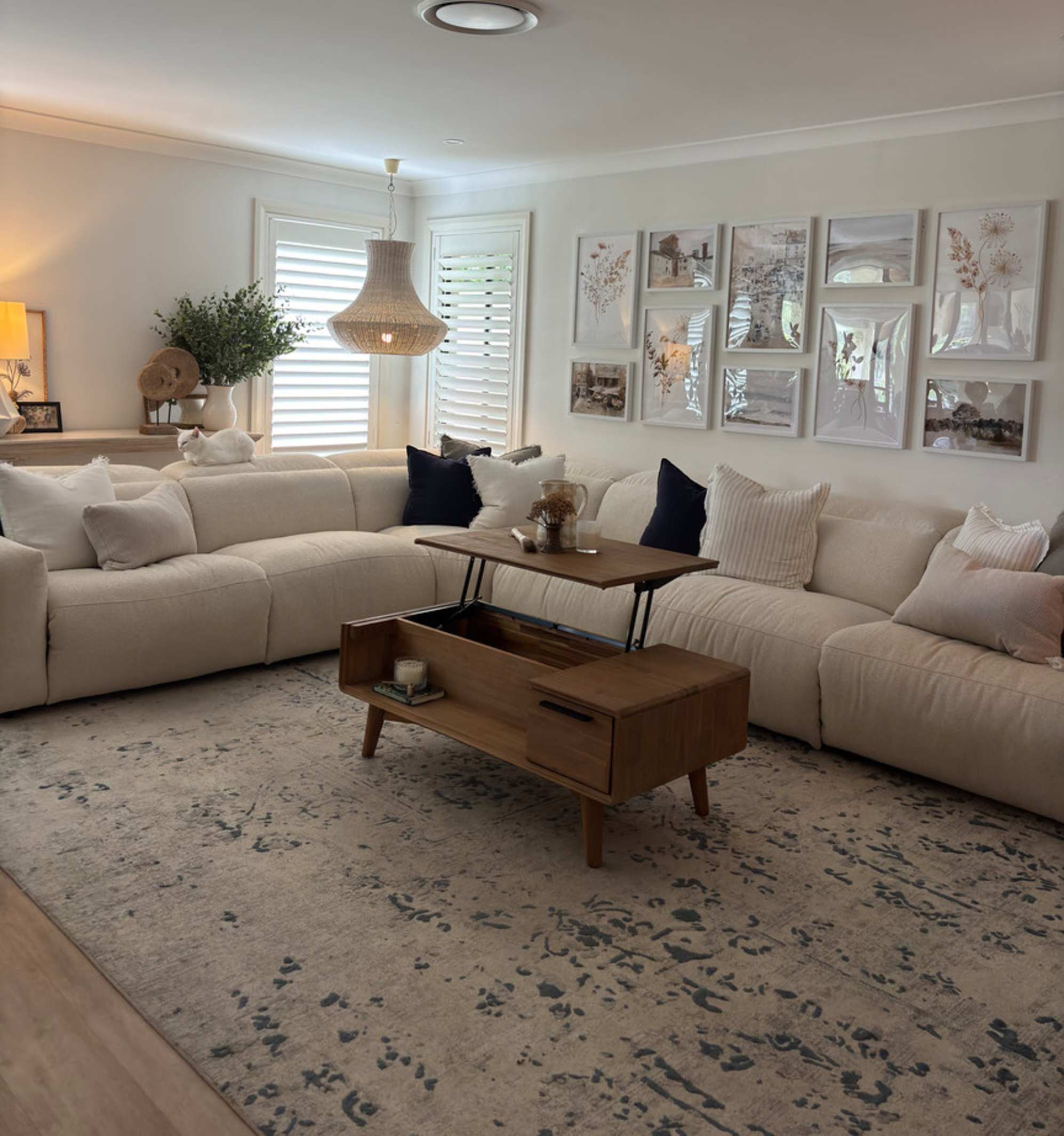 A wooden coffee table with a lift-top functionality placed in a living room.