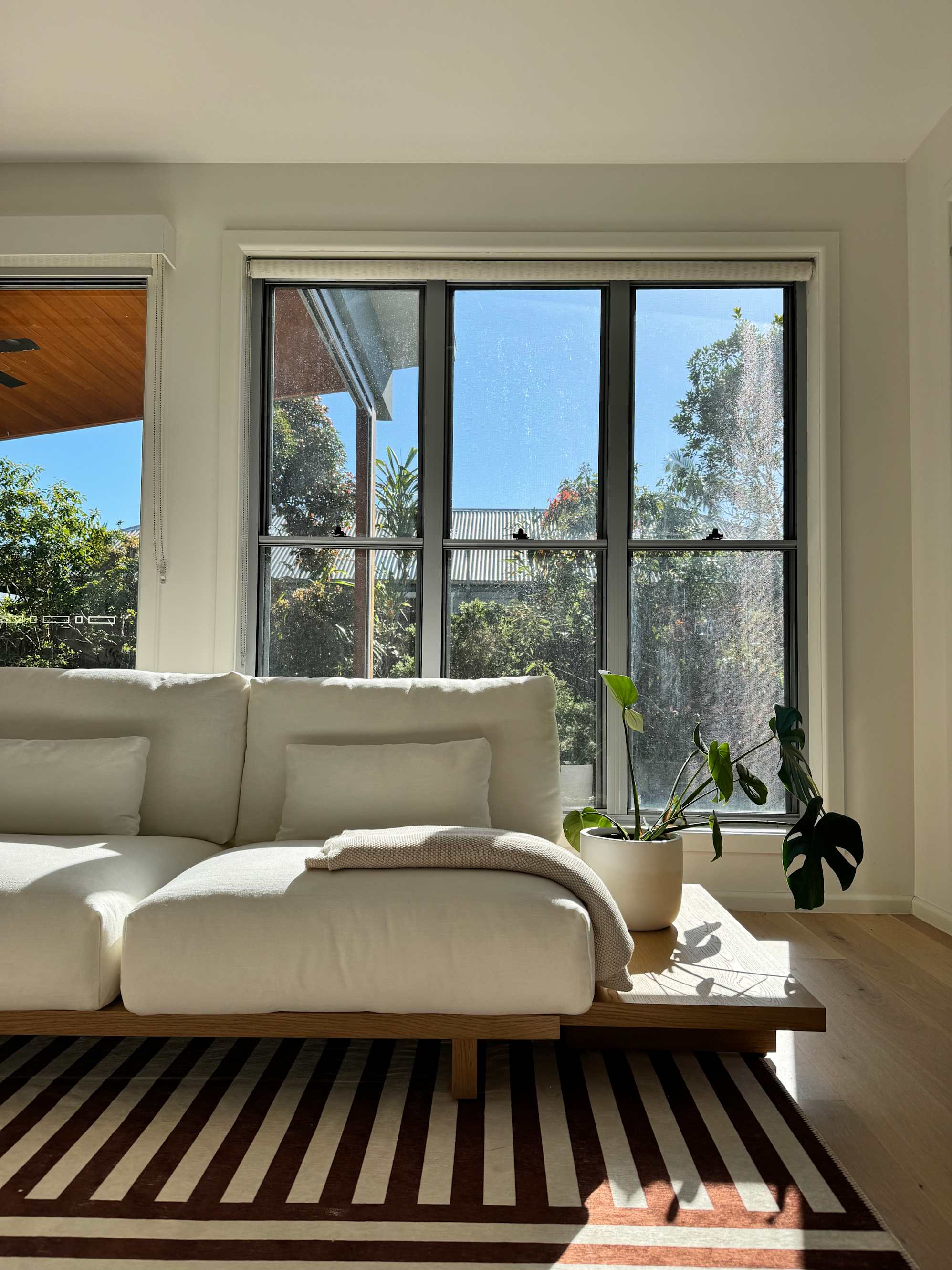 A dog sitting on an outdoor lounge chair, with a bar cart beside it