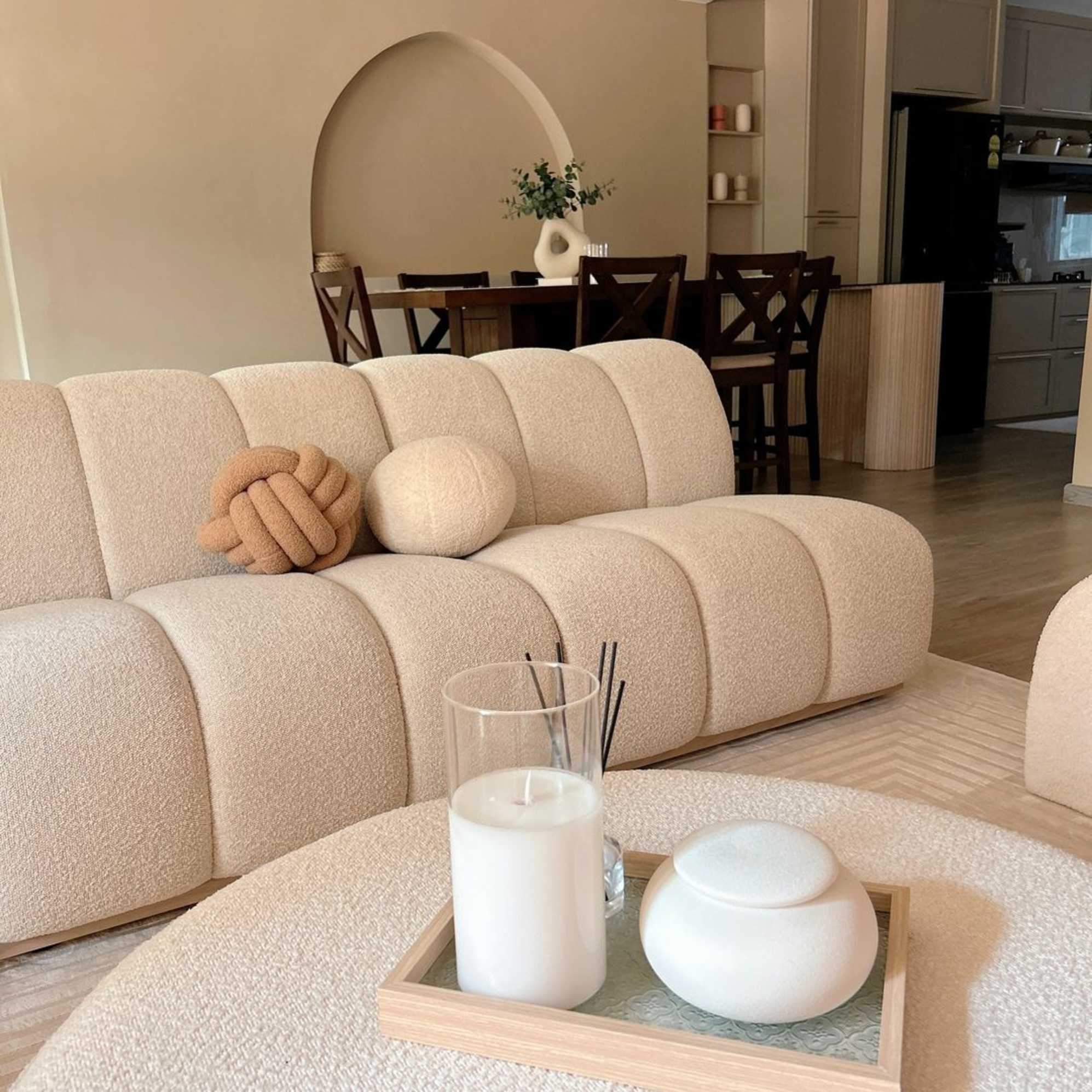 A living room area infront of a dining room in an open floor plan.