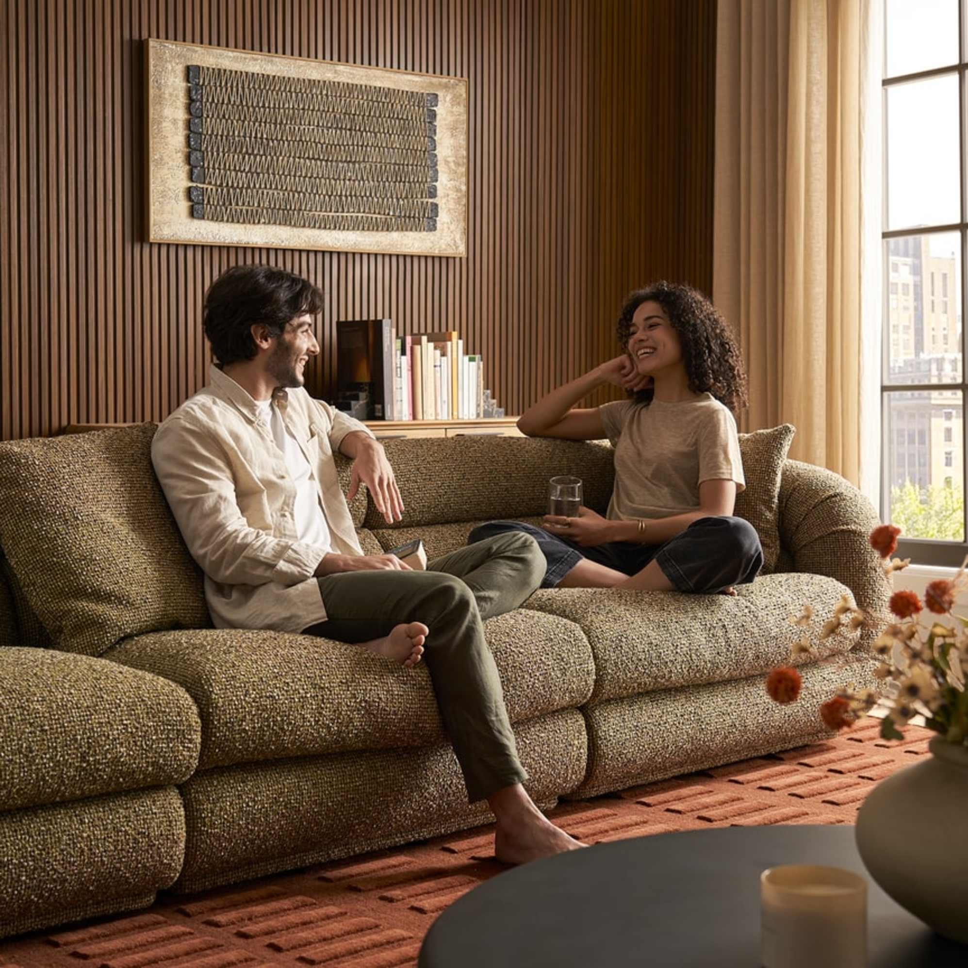Two people sitting on a chunky performance fabric sofa talking.