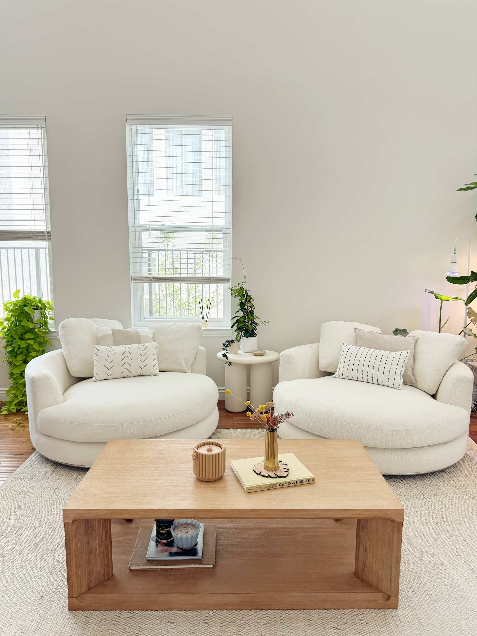 A side table between 2 swivel armchairs.