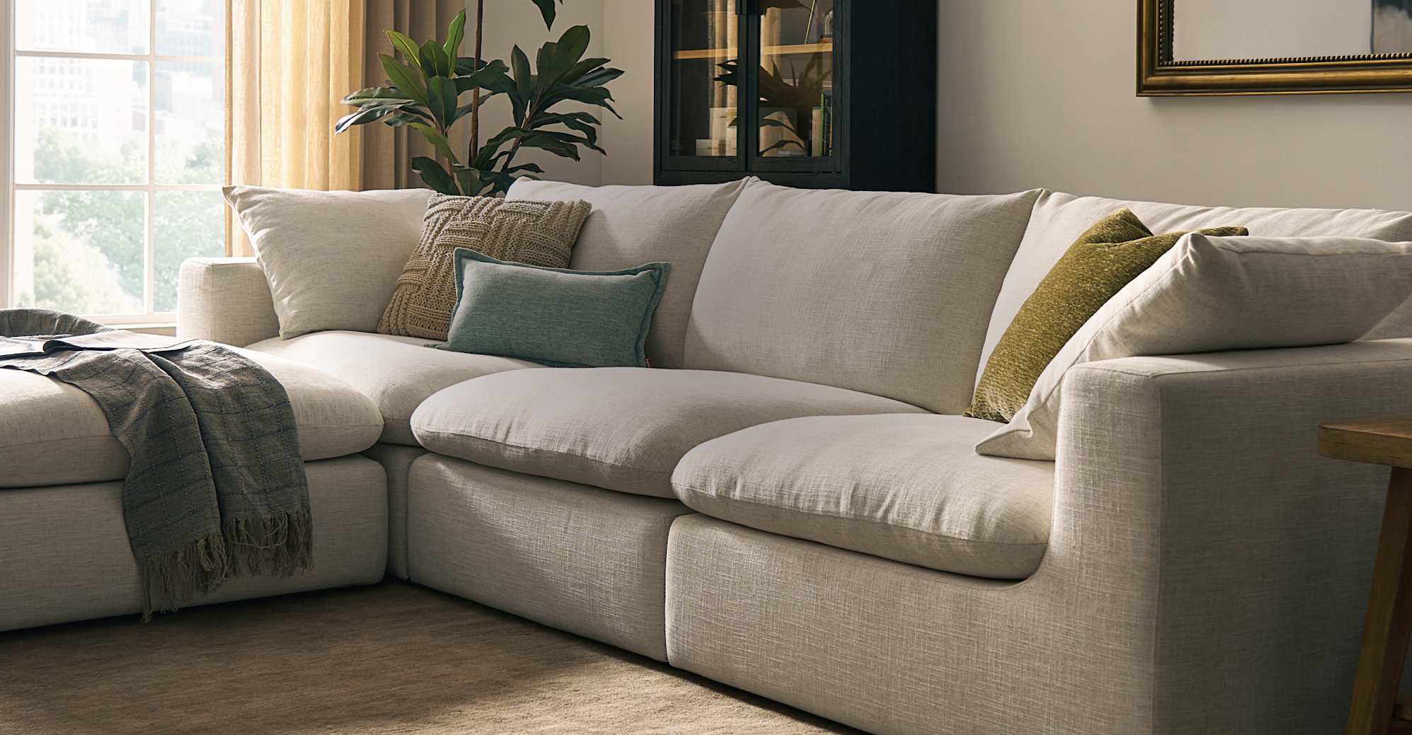 White extended chaise sofa with pillows in a living room