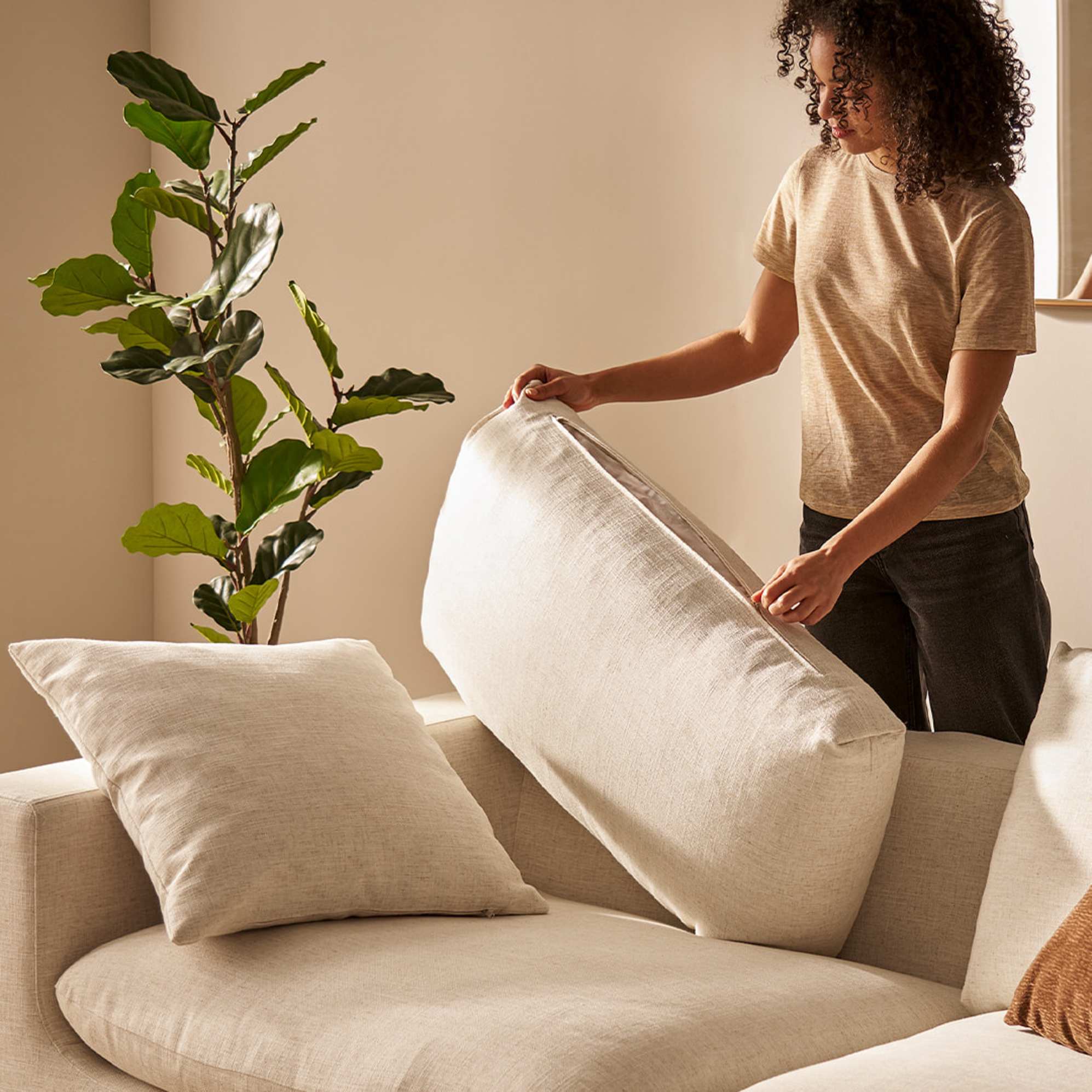 A person unzipping a sofa cushion.