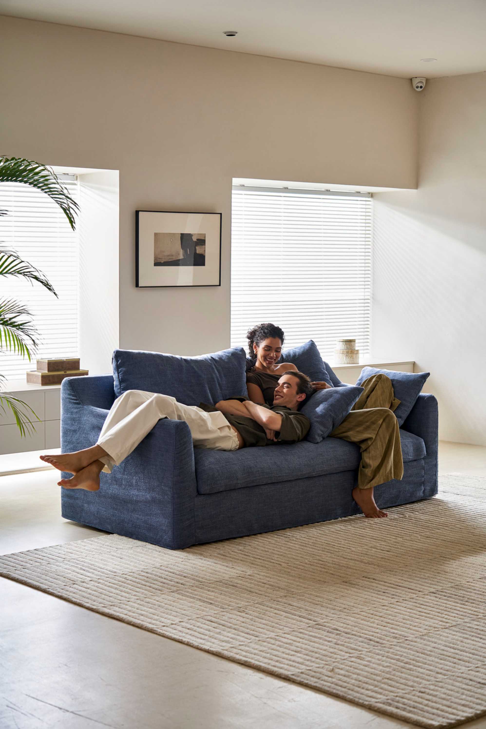 Two people lying down on a cover with a blue slipcover.
