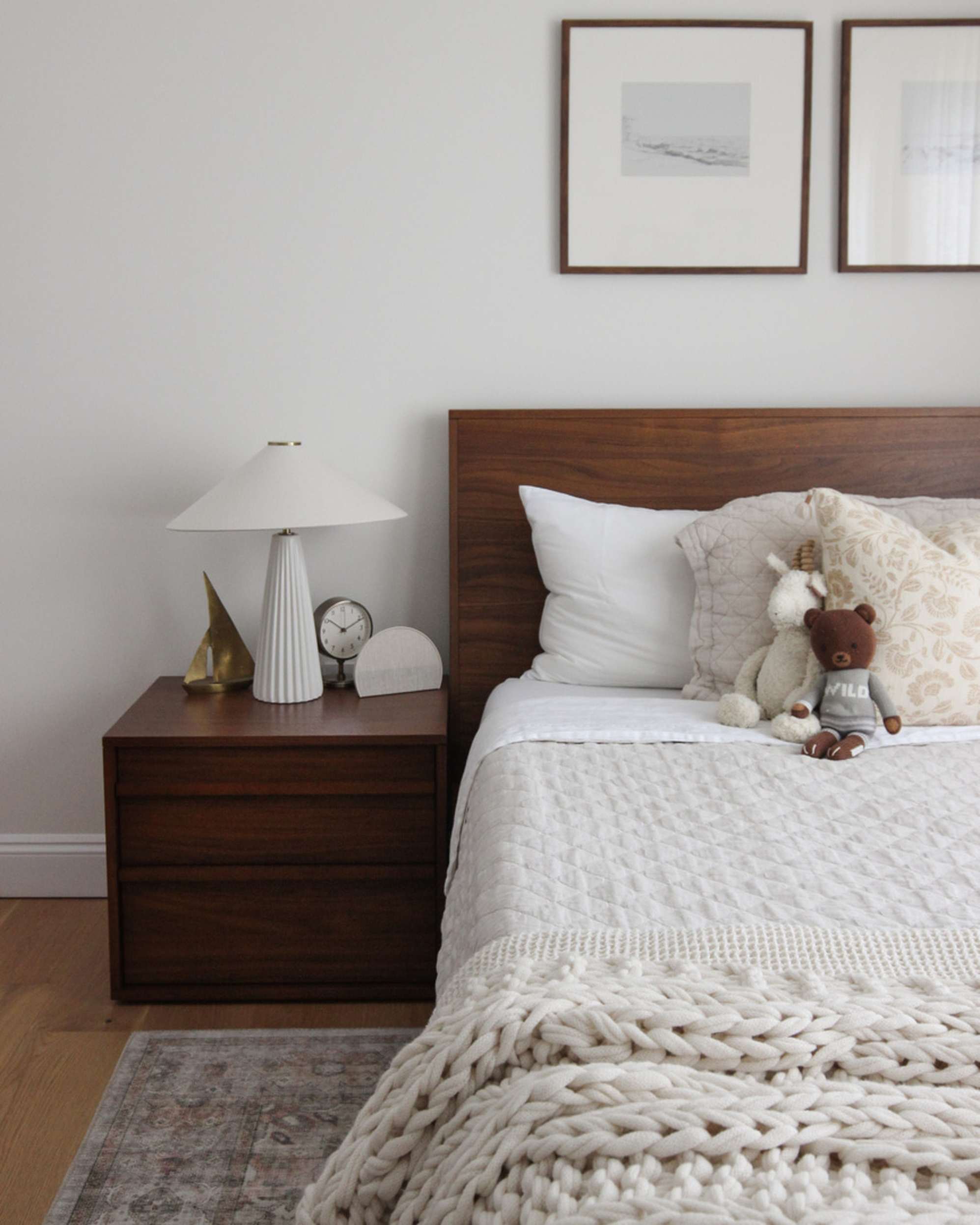 A bed frame with a wooden headboard and a matching bedside table placed in the bedroom.