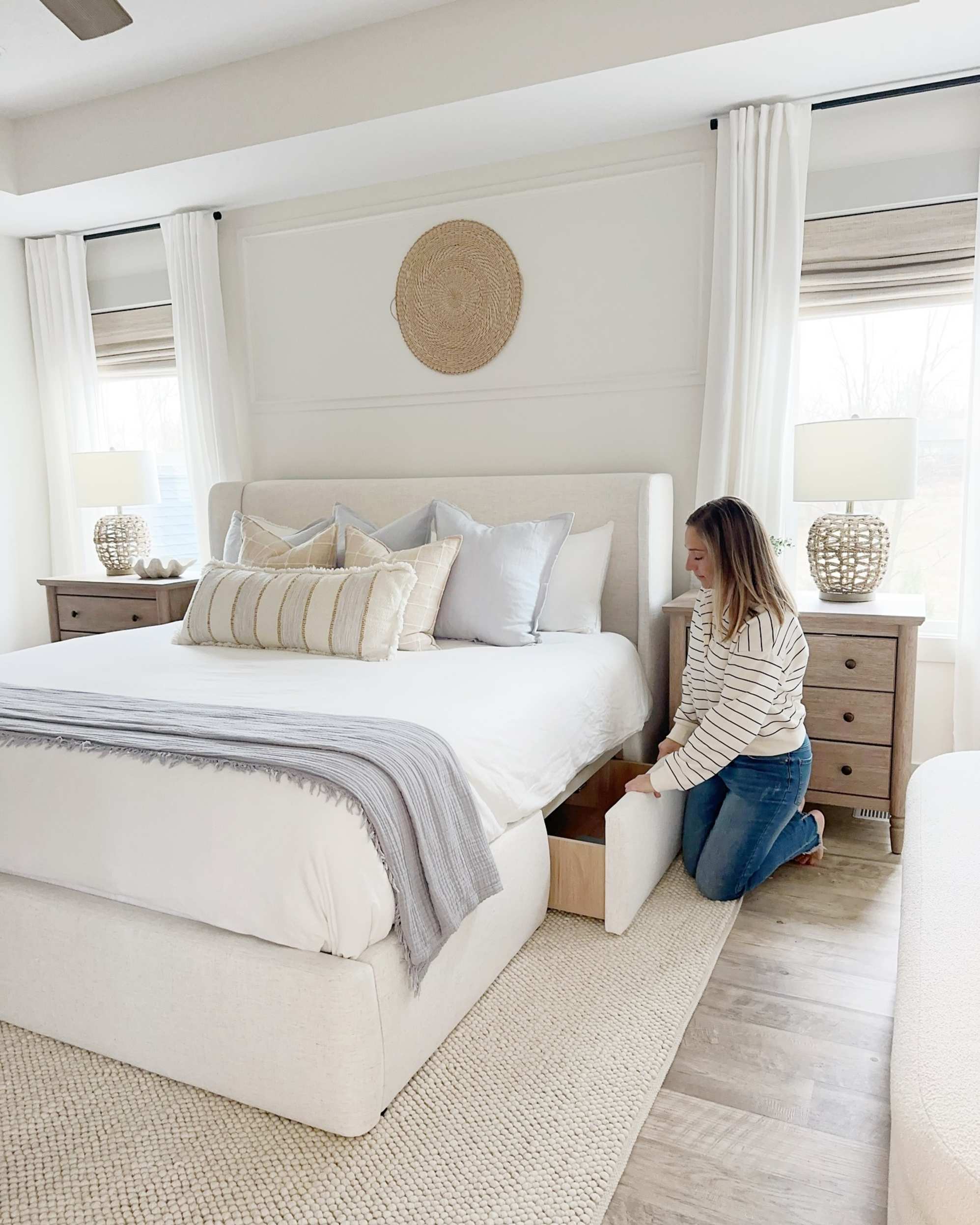 White storage bed frame with woman pulling out drawer in bedroom