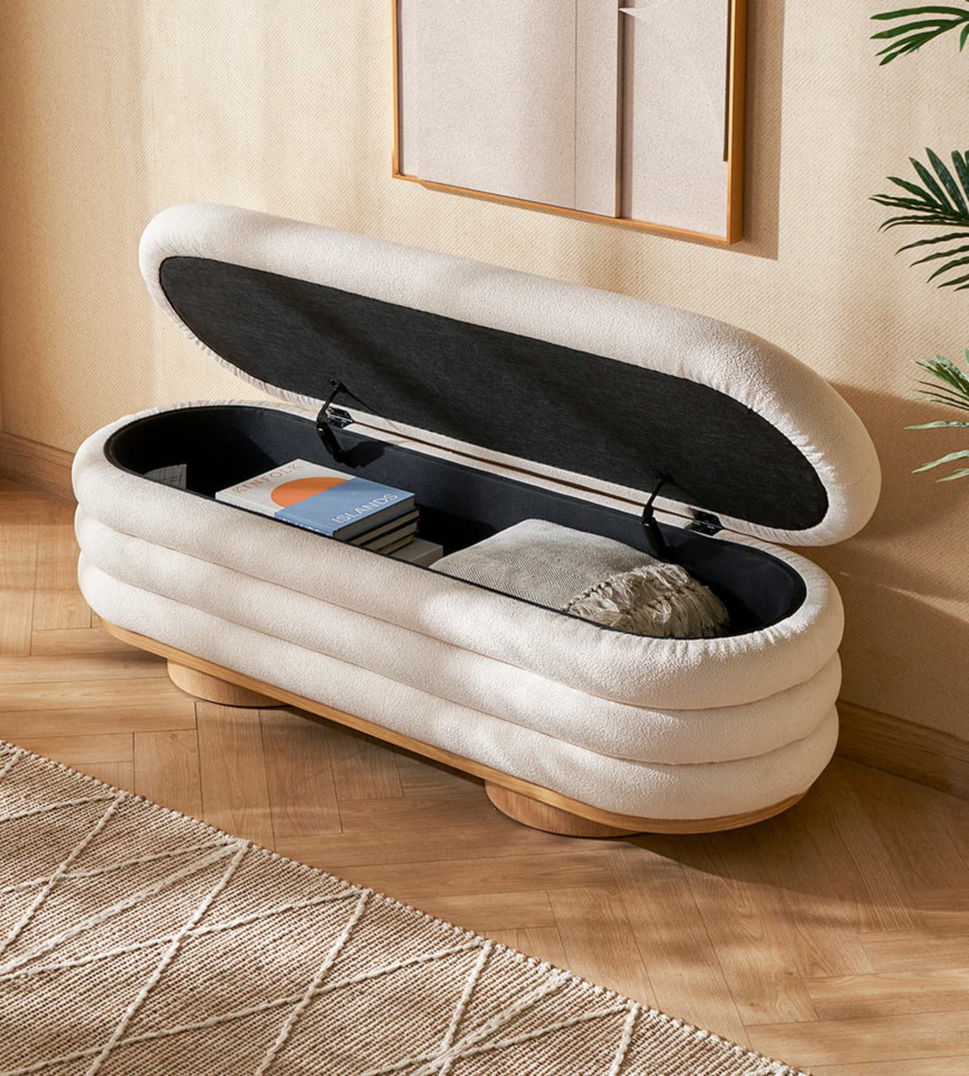 A performance fabric bench with its top lifted to reveal books and pillows stored beneath.