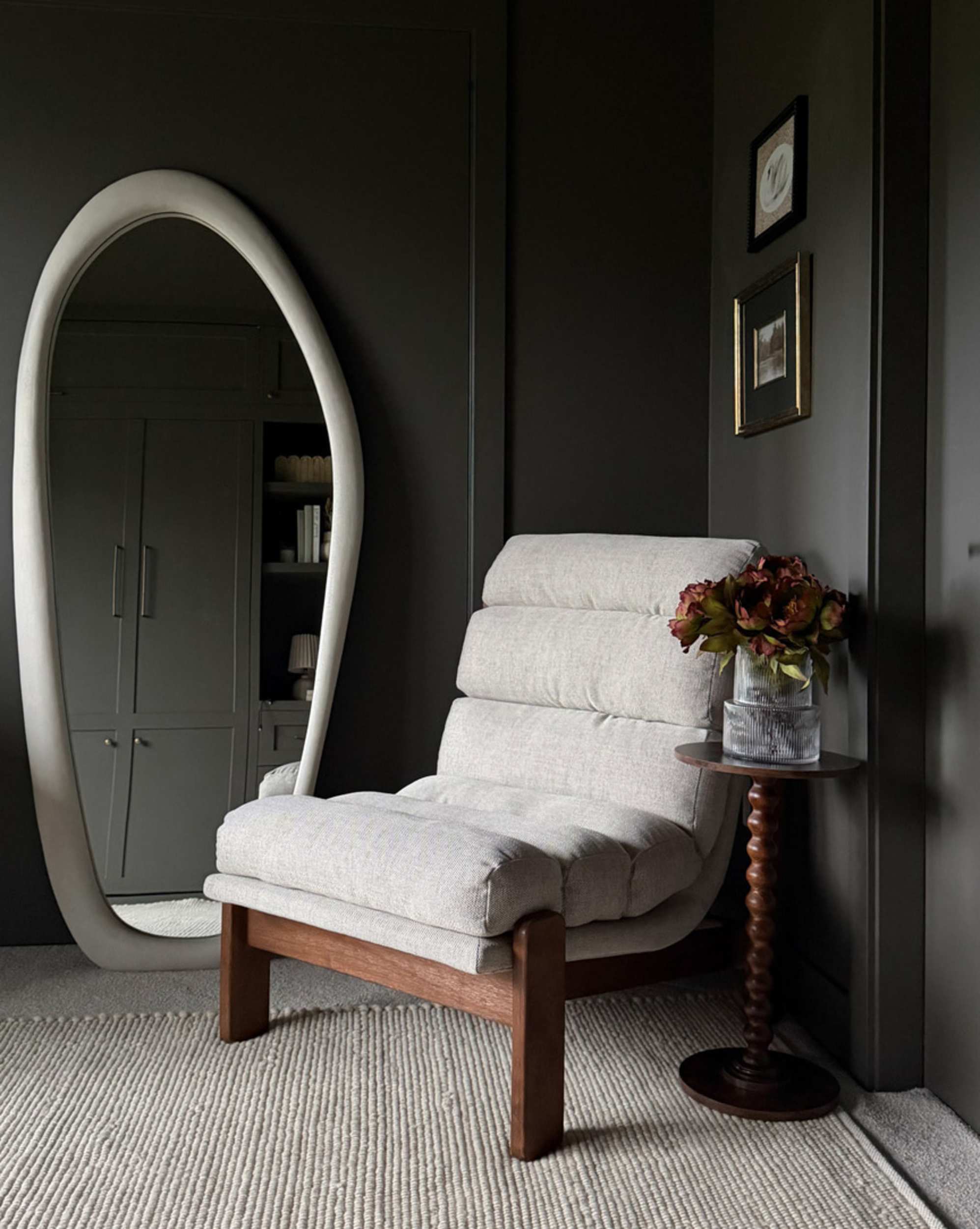 A floor mirror placed beside an accent chair in a room.