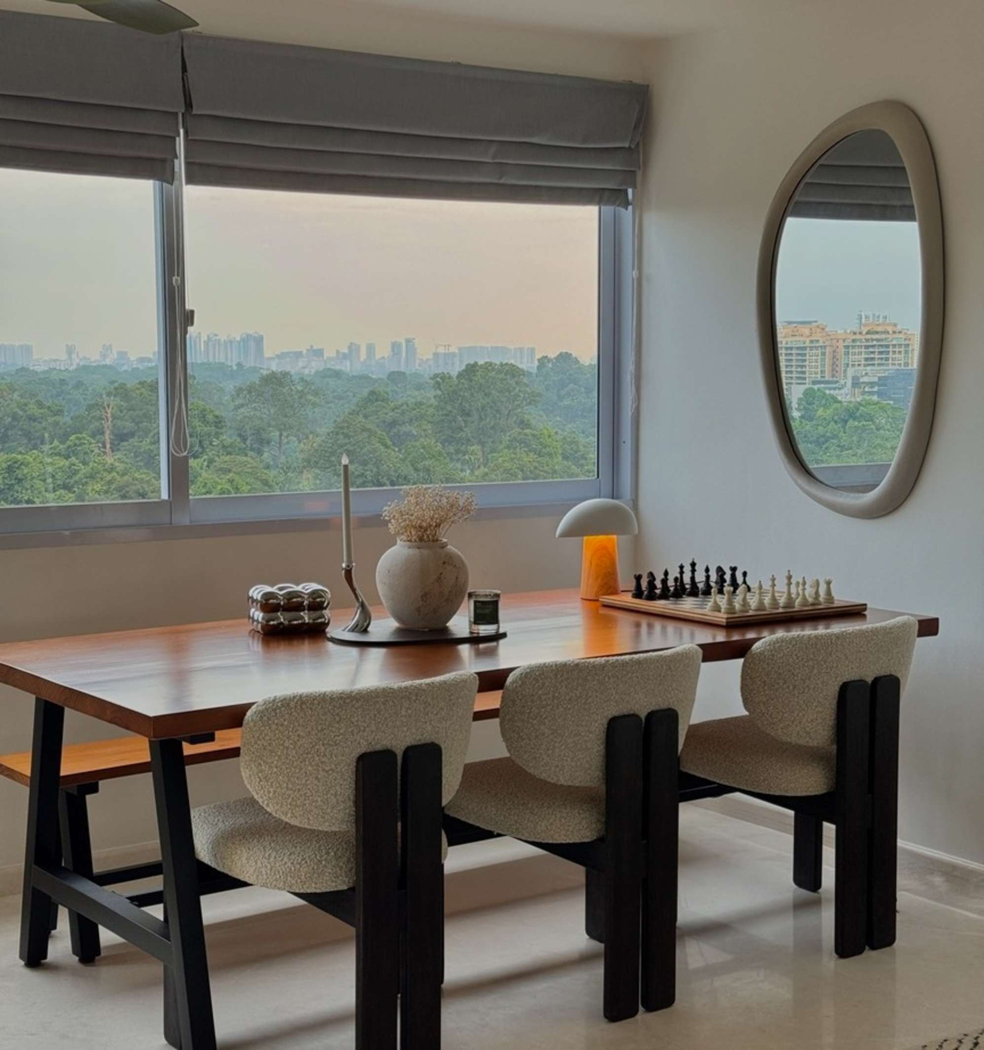 A mirror placed on the wall next to a wooden dining table.