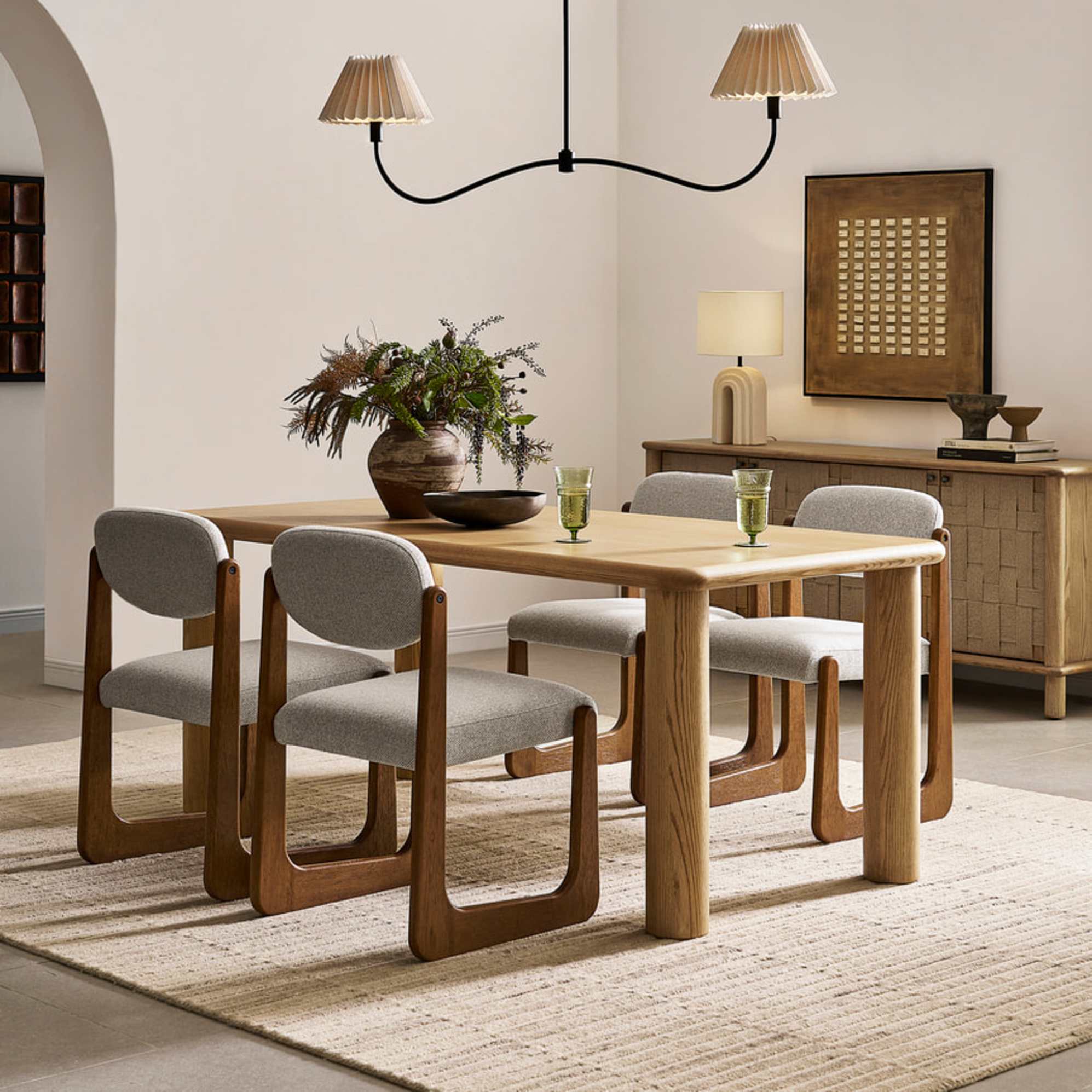 A wooden dining table with four upholstered dining chairs with a wooden frame.