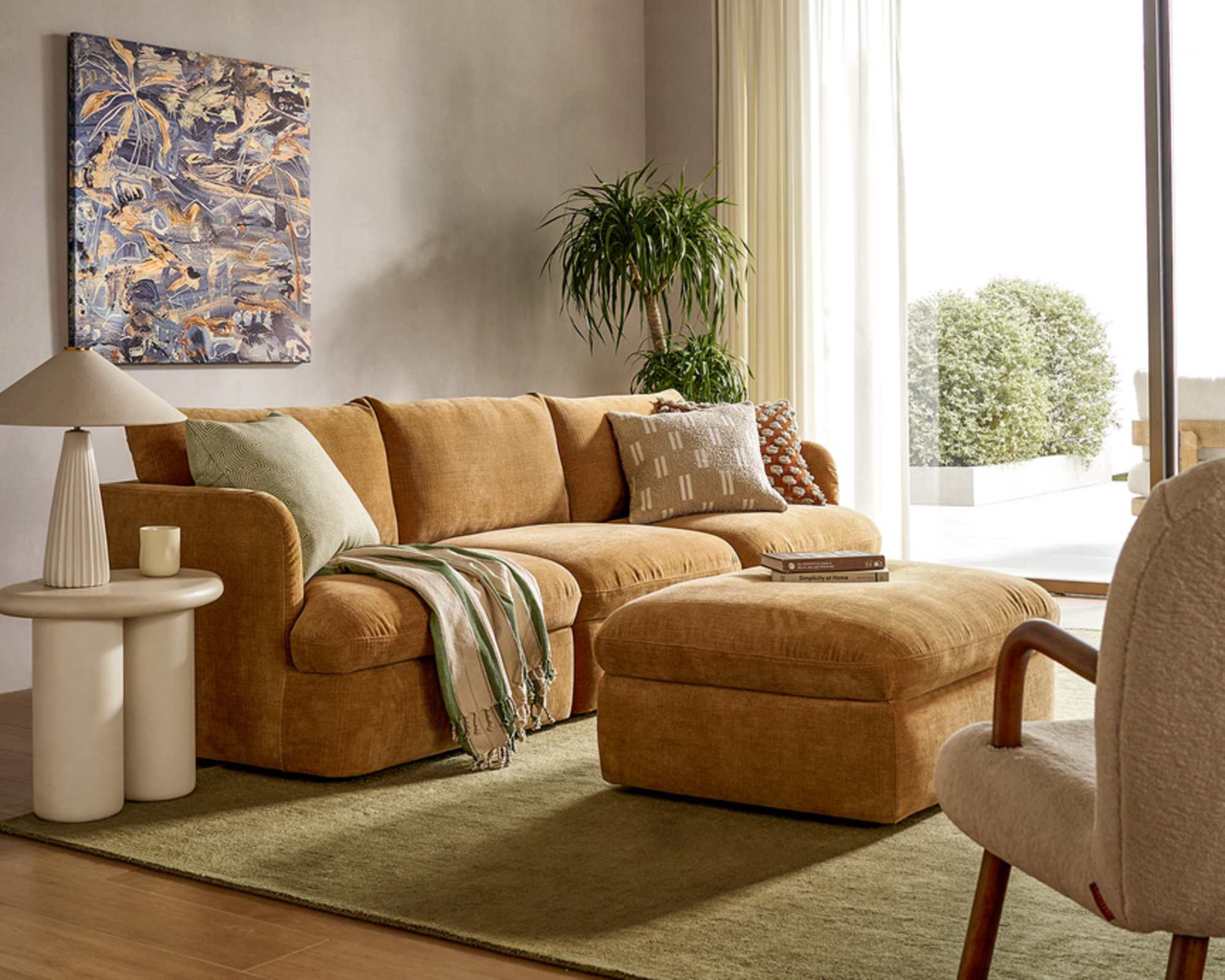 An extended 3-seater sofa with storage and a matching ottoman placed in a living room.