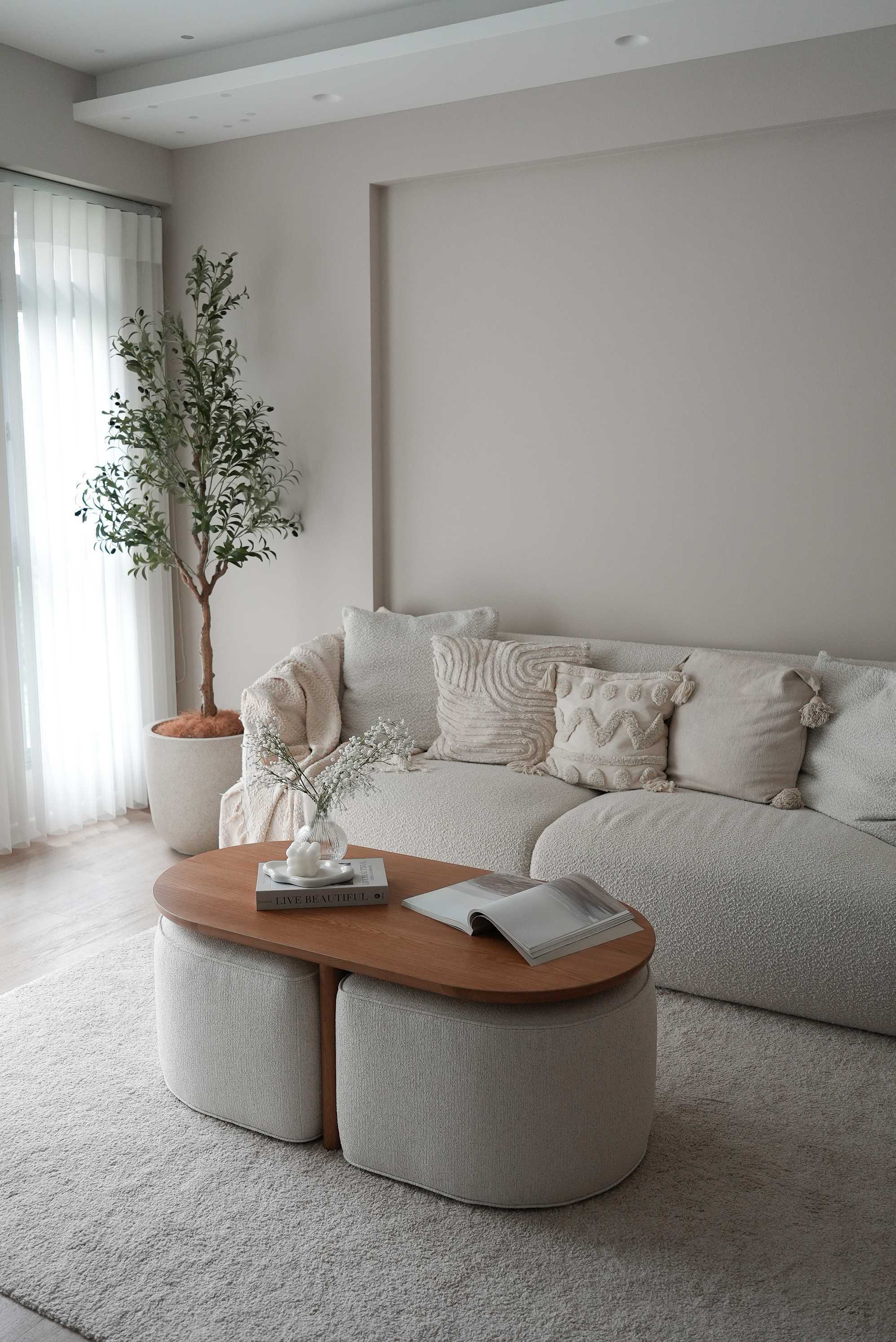 A low-slung armchair placed infront of a fireplace with a matching marble coffee and side table set.
