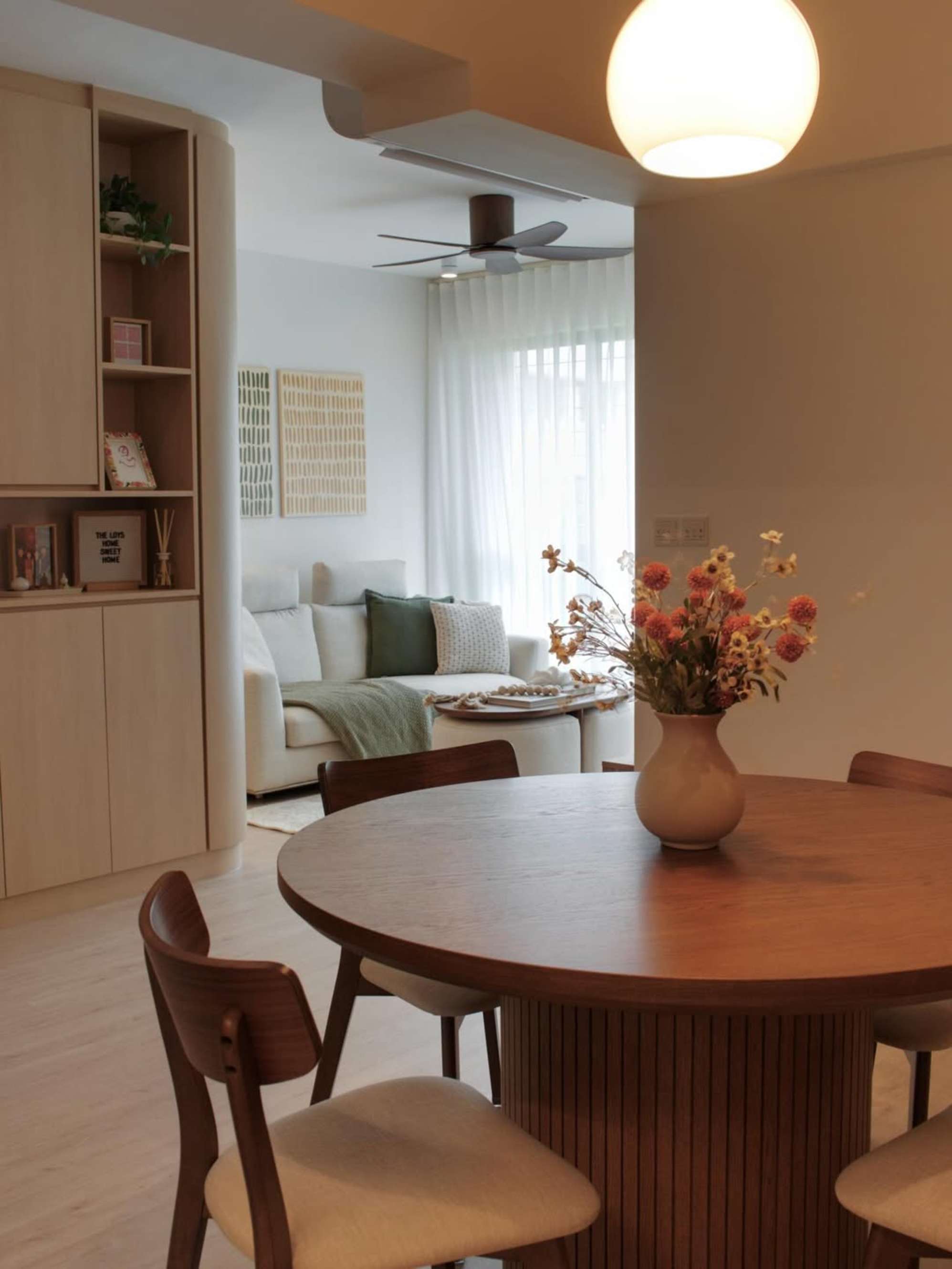 A round wooden dining table placed adjacent to a living area.