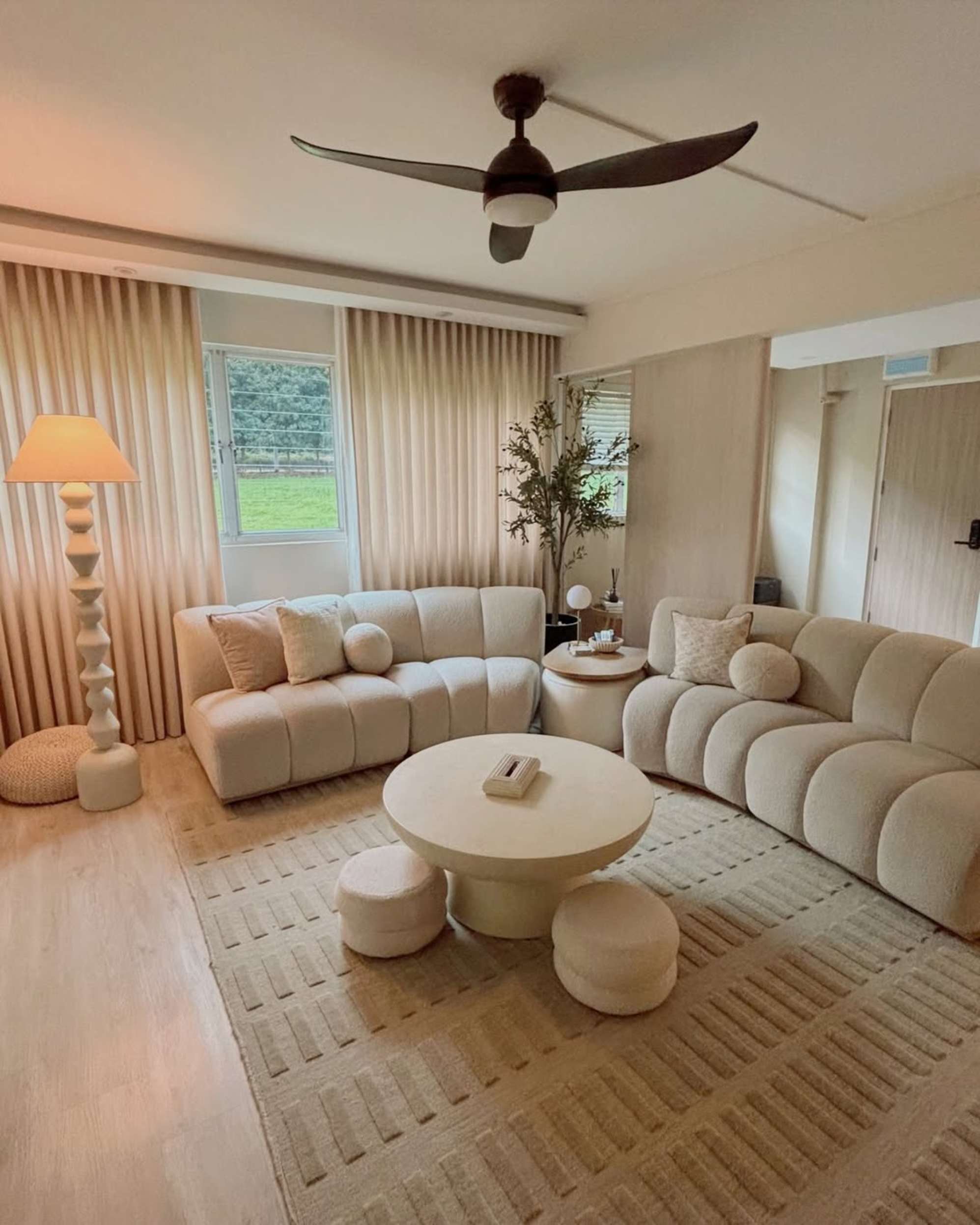 Two armless bouclé modular sofas split up and placed in a living room around a white coffee table.