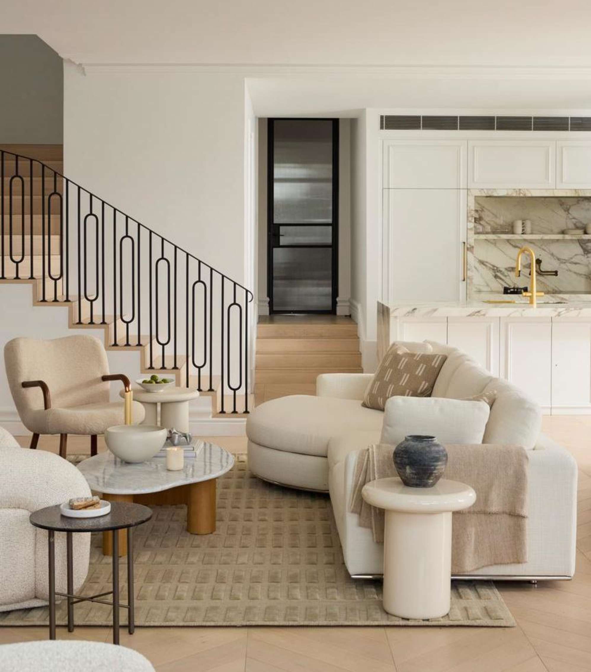 A round chaise sectional sofa paired with a marble coffee table in a living room.