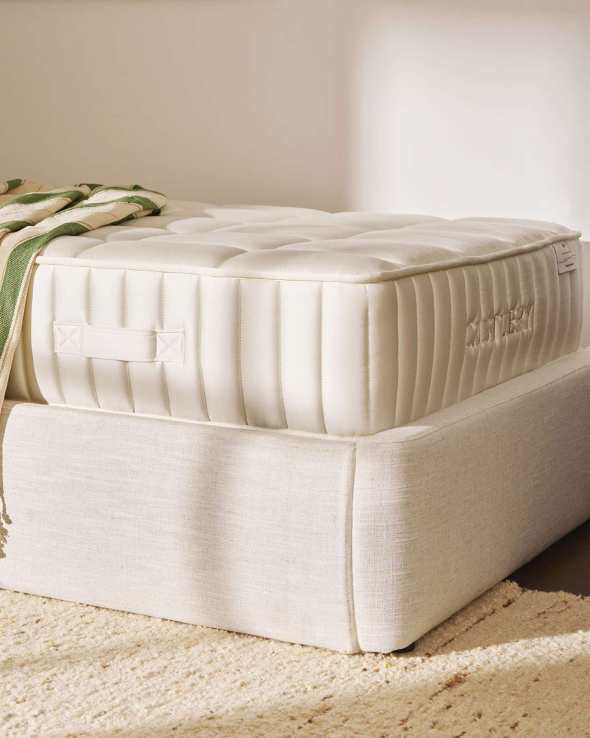 A single-sized mattress placed on a storage bed.