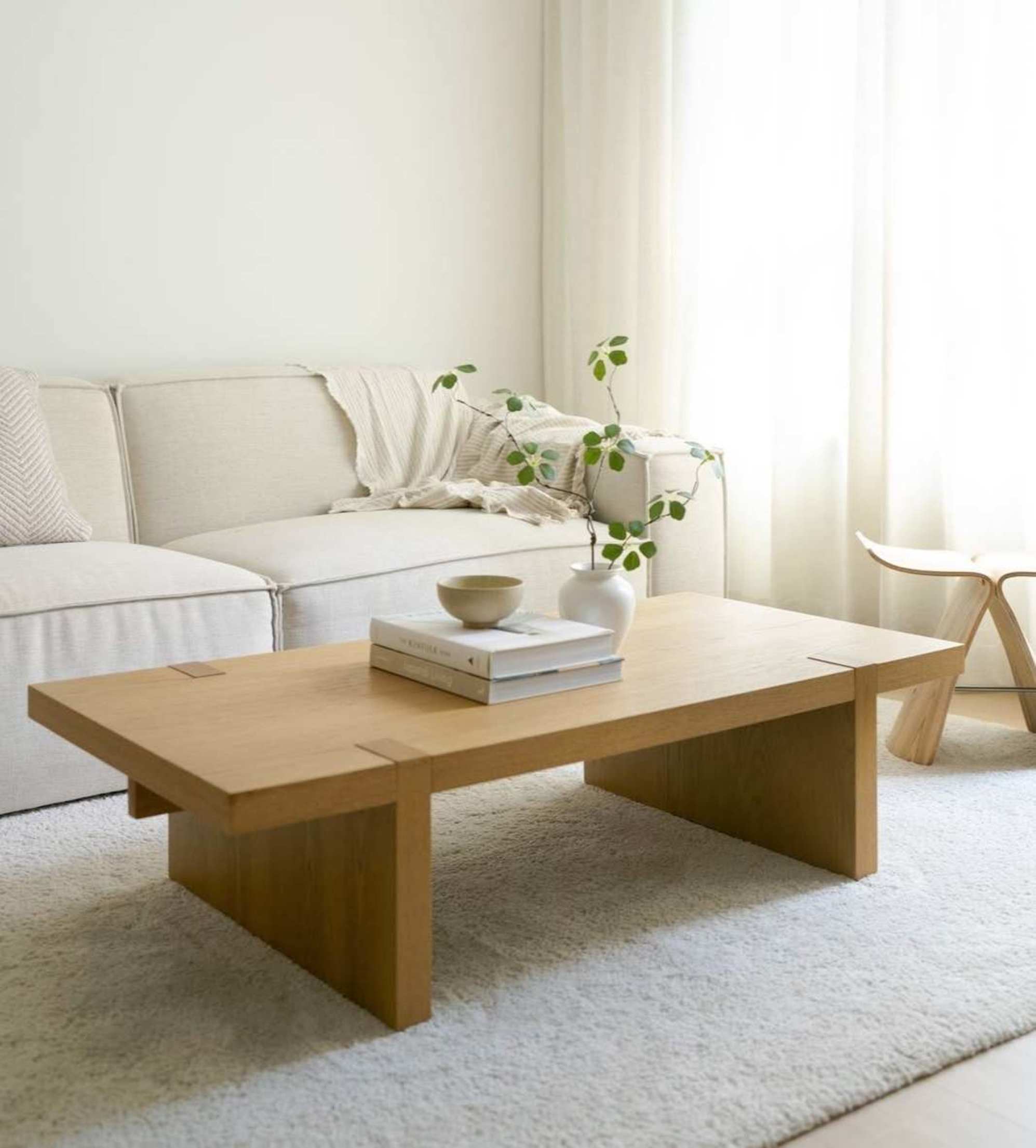 A wooden coffee table placed atop a plush rug in the living room.