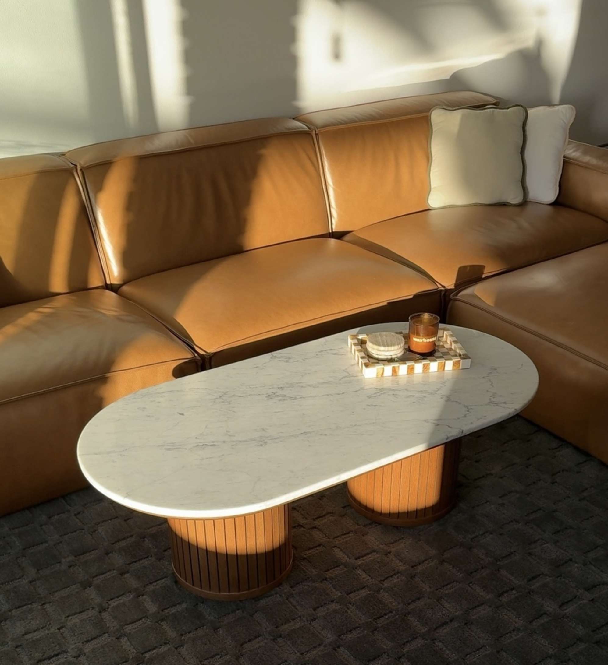 A marble coffee table placed in the living room with a leather sofa.