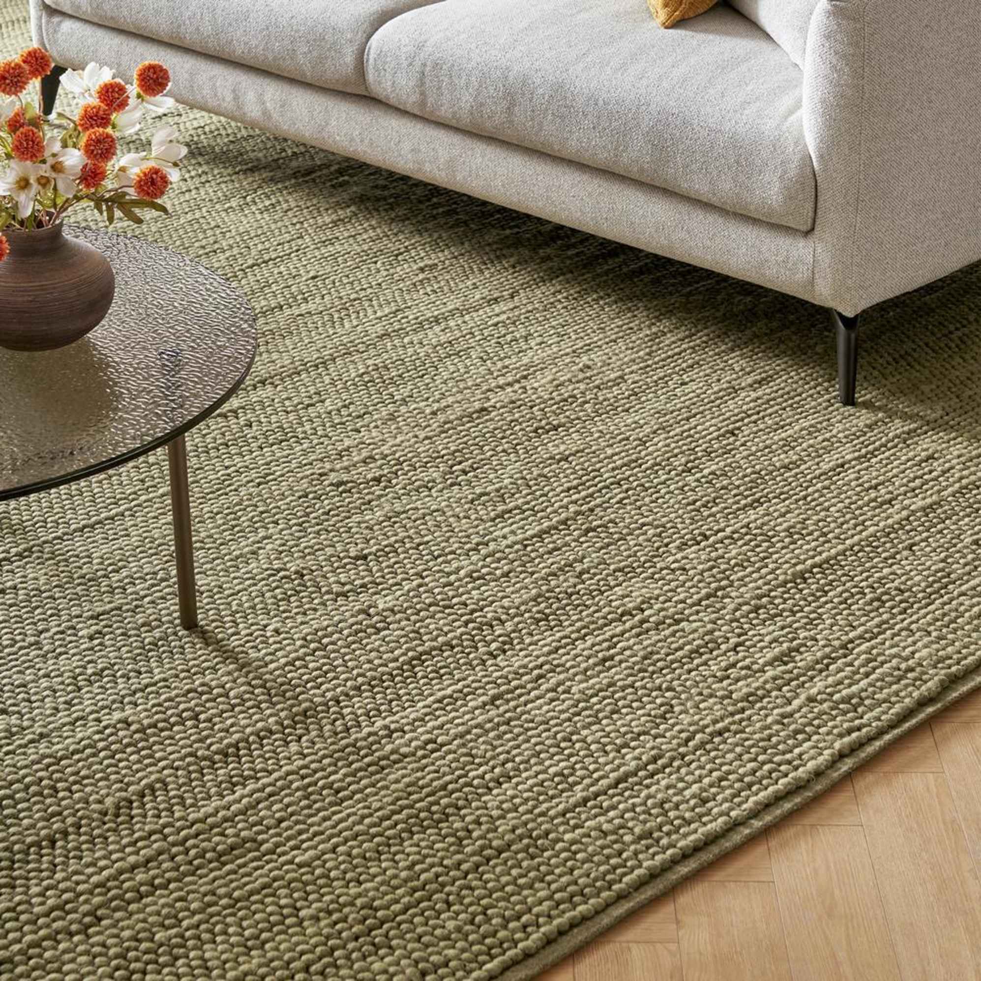 An olive-colored rug placed in a living room.