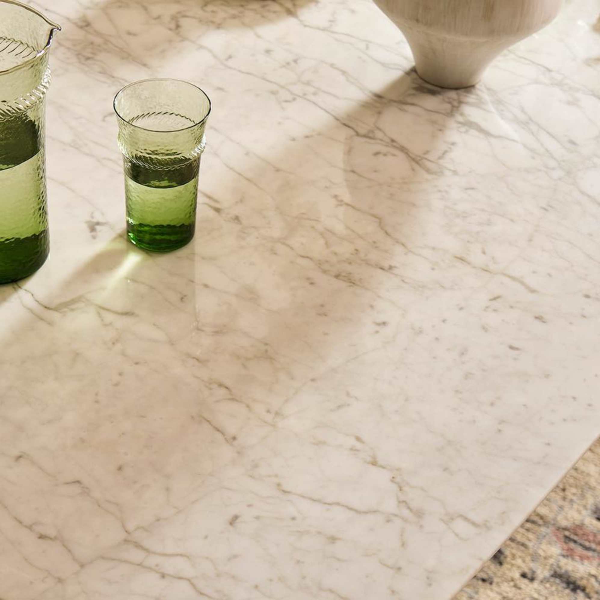 A close-up shot of a marble dining table with blue-ish grey veining.
