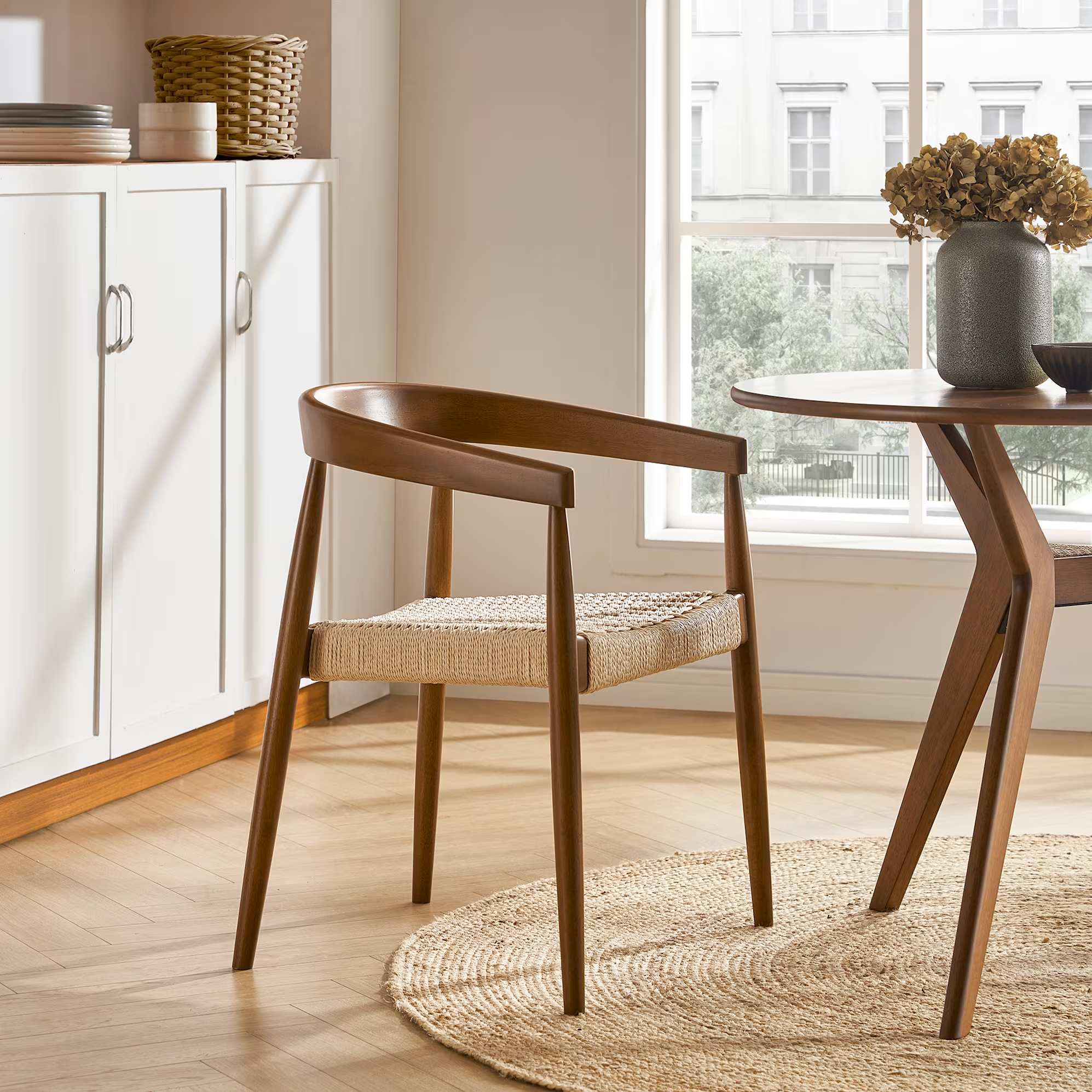 A woven dining arm chair in a walnut stain.