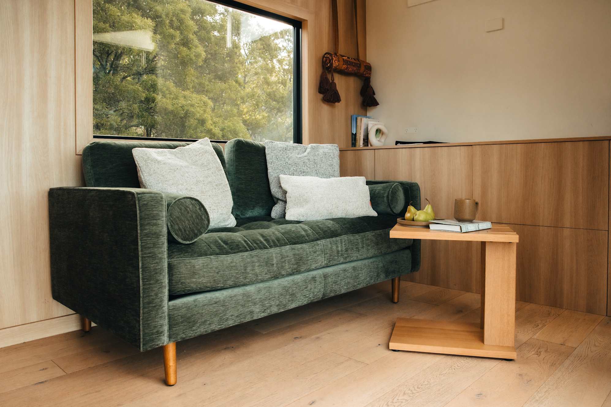 Green 2 seater sofa in a tiny home.