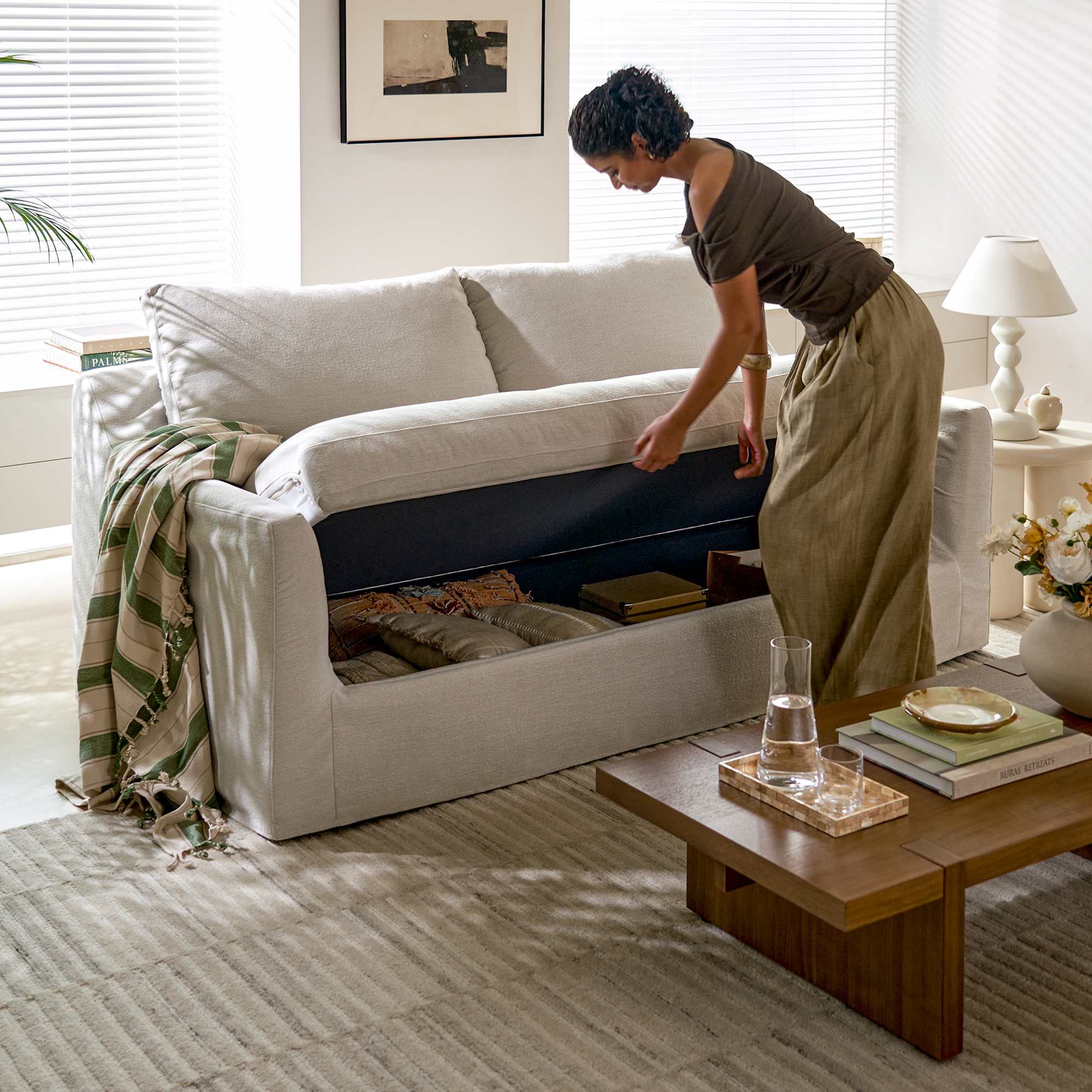 A woman placing items into a storage sofa