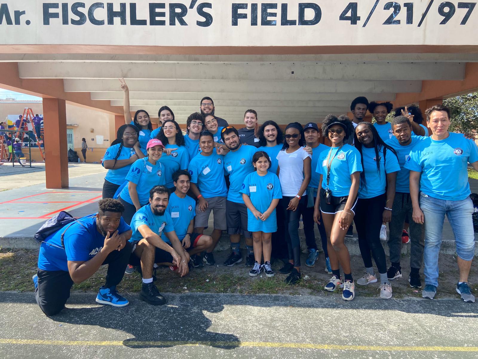 Bosco and a large group of friends all posing and wearing matching Miami Dade College shirts