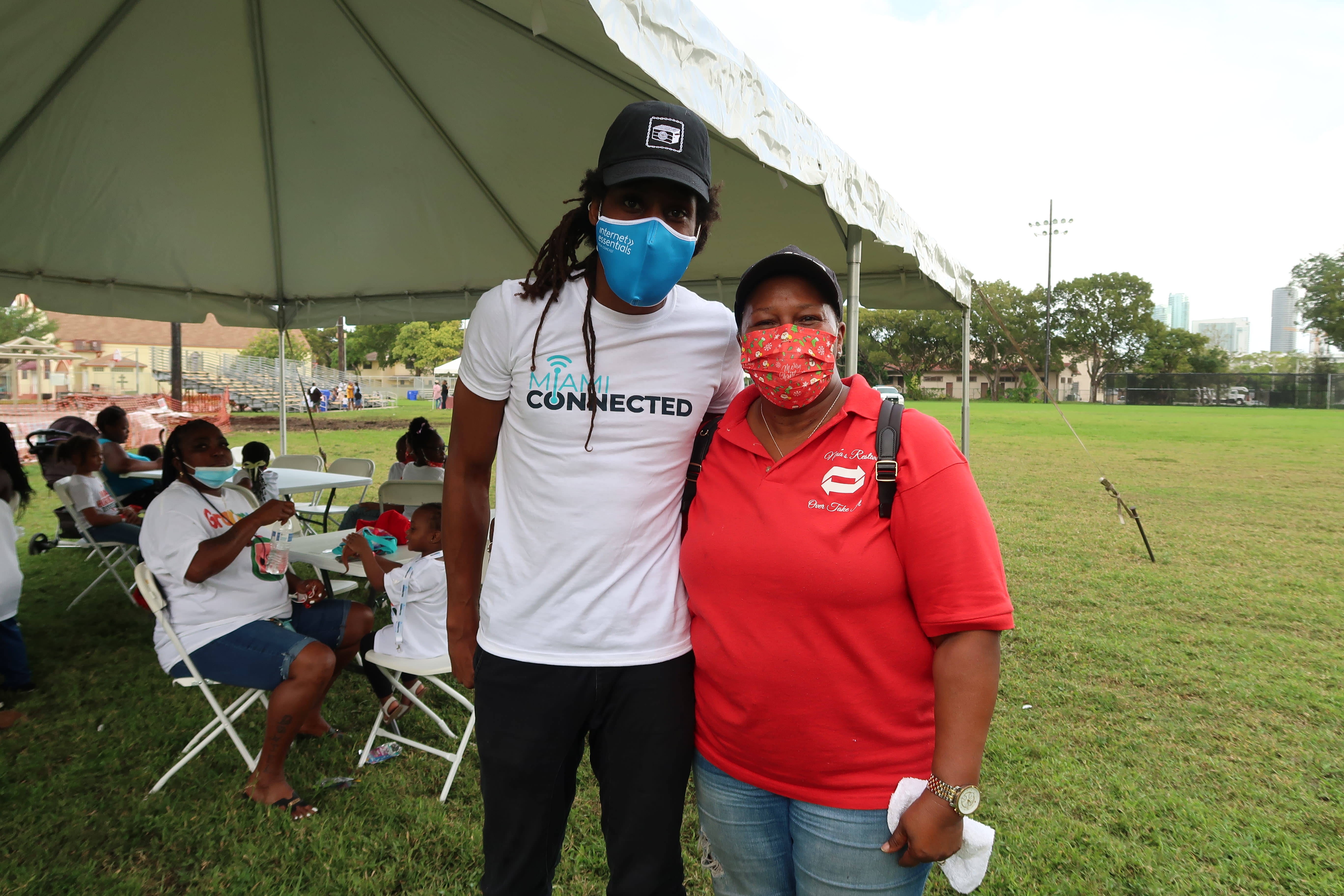 Mama Joy and a black man from Miami Connected pose with their masks on.
