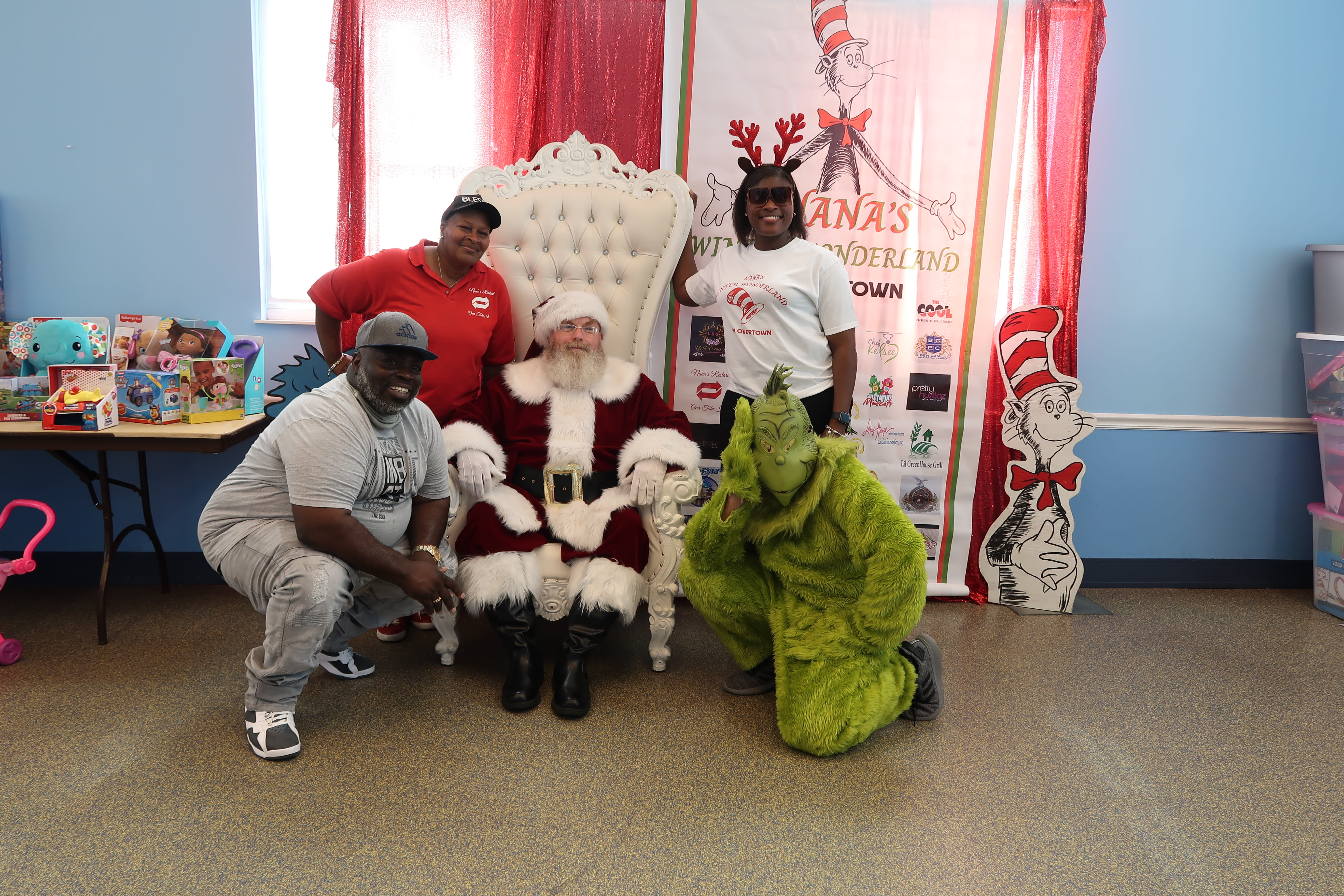 Mama Joy and her family pose with Santa and the Grinch.
