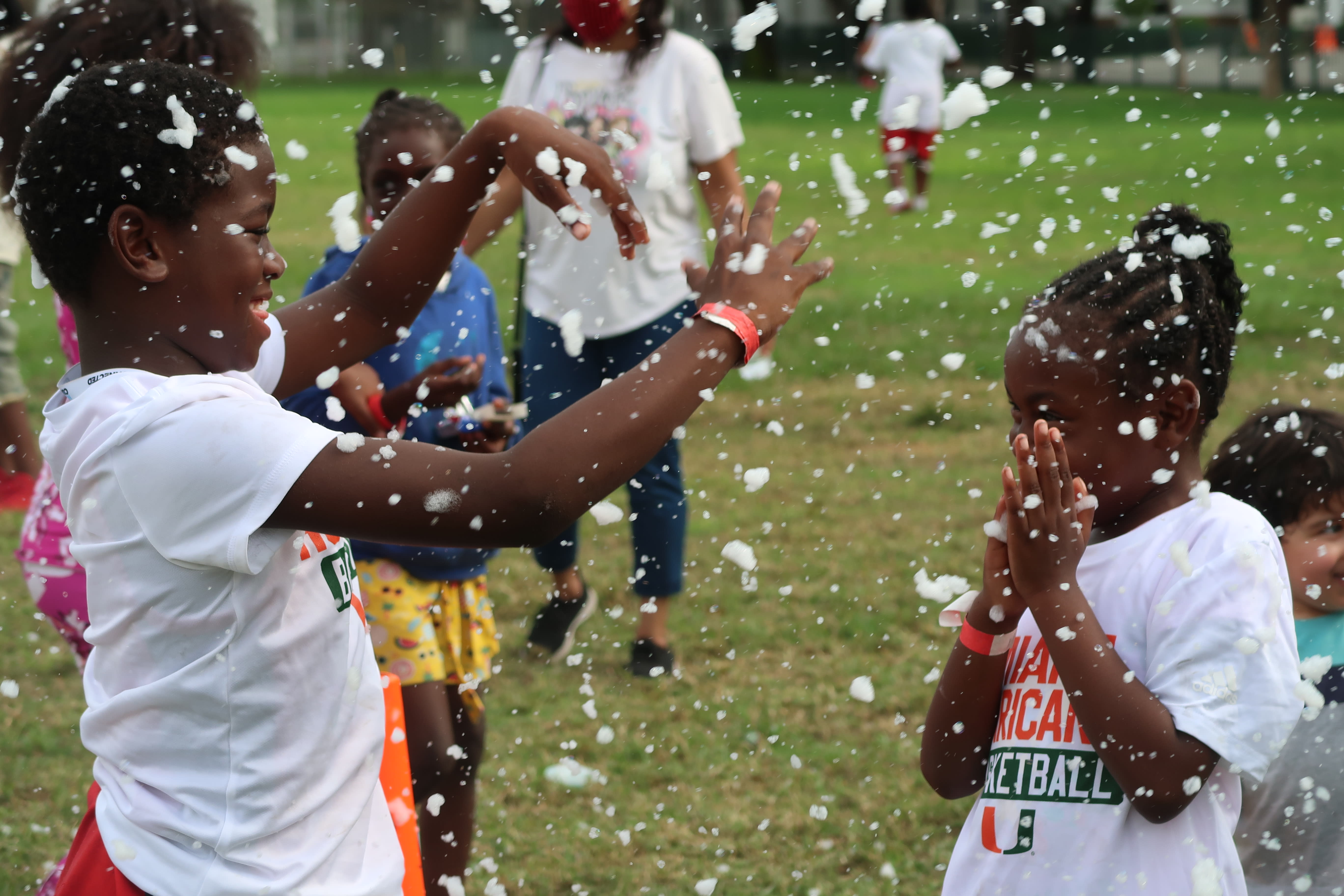 Several young black kids play in a snow machine.
