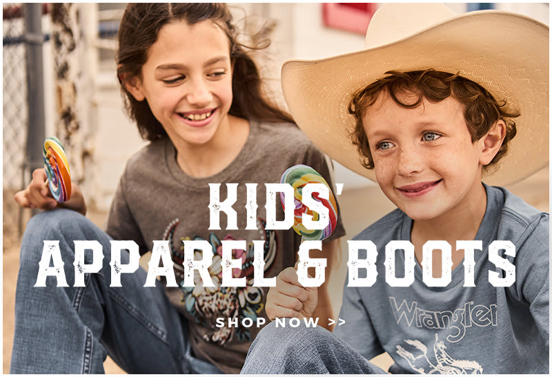 An image of a boy and girl wearing western apparel and eating a multicolored lollipop.Text at the bottom reads "KIDS' APPAREL & BOOTS SHOP NOW". Click to shop.