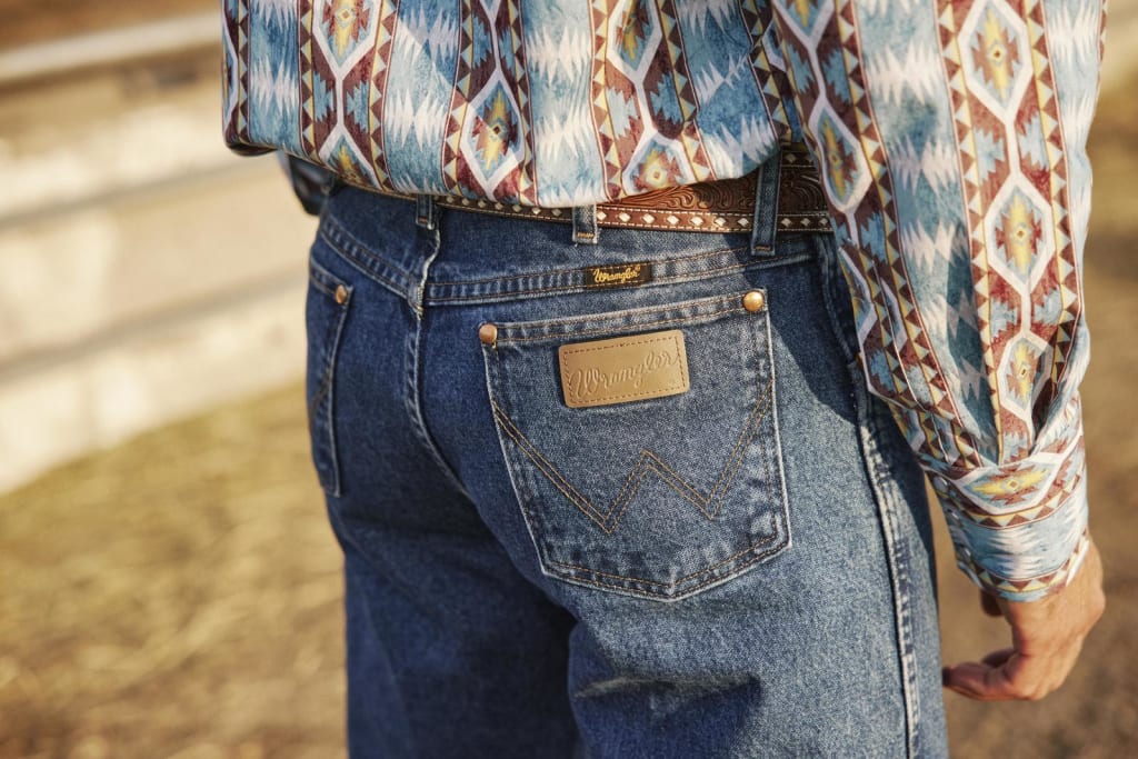 Back view of a man in Wrangler jeans, wearing a western belt and shirt.