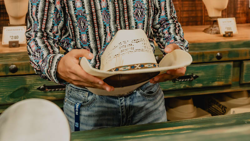 A Cavender's employee adding the finishing touch to a cowboy hat, ensuring the perfect shape and fit.