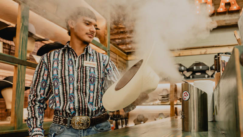 A professional hat shaping service in action at Cavender's, with steam rising as the hat is shaped.