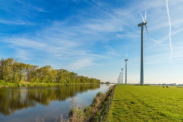 Afbeelding met windmolens in een weiland dat de een onderzoek naar duurzame energie en de duurzaamheid van energieleveranciers uitbeeldt.