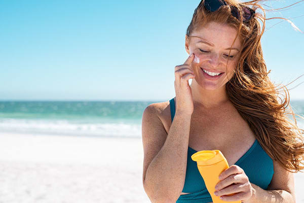 Zonnebrand gezicht smeren strand