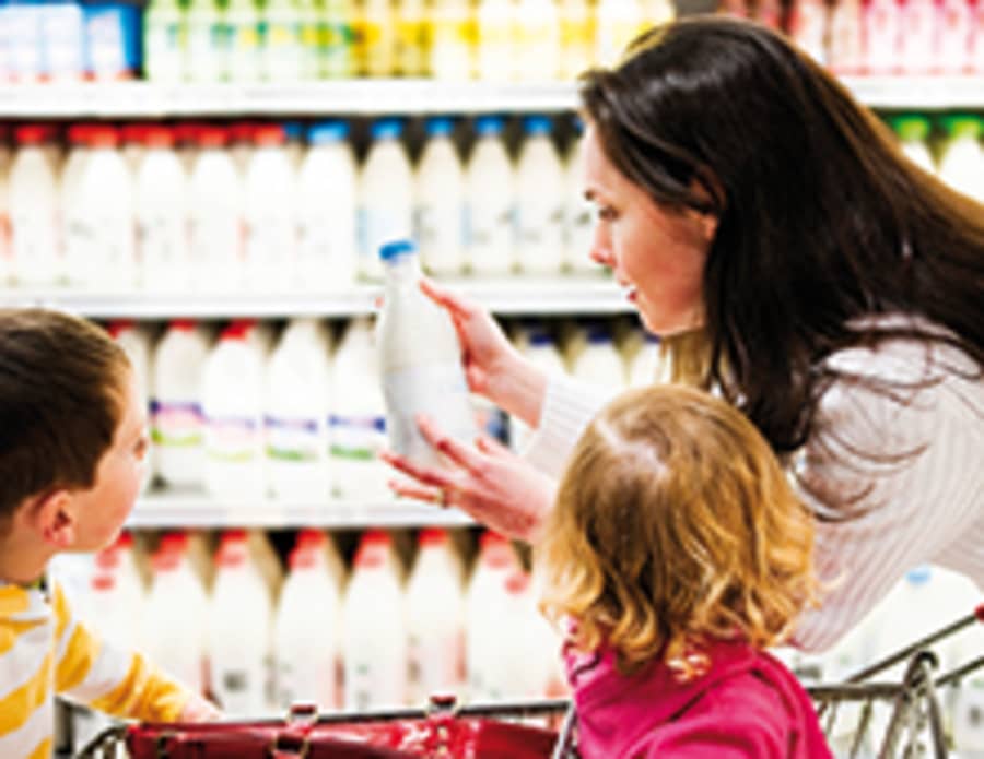 Moeder met kinderen doet boodschappen in supermarkt