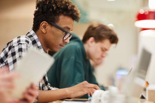 Two students work at their laptops