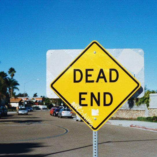 A photograph of a street sign reading "dead end"