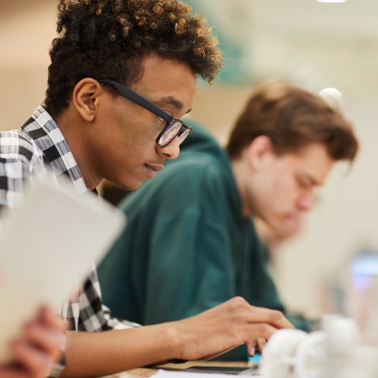 Two students work at their laptops