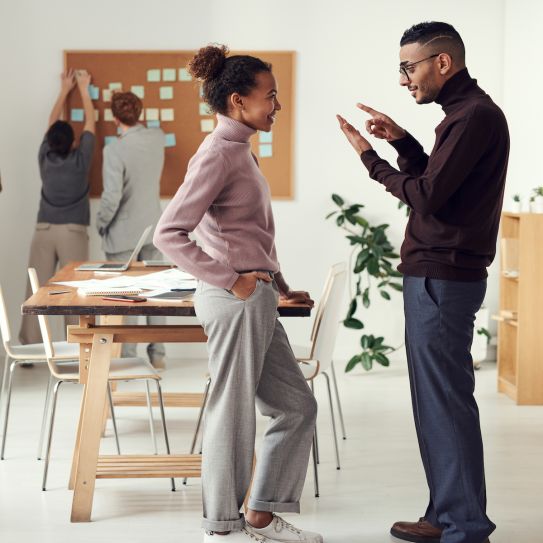 two people in an office talking 